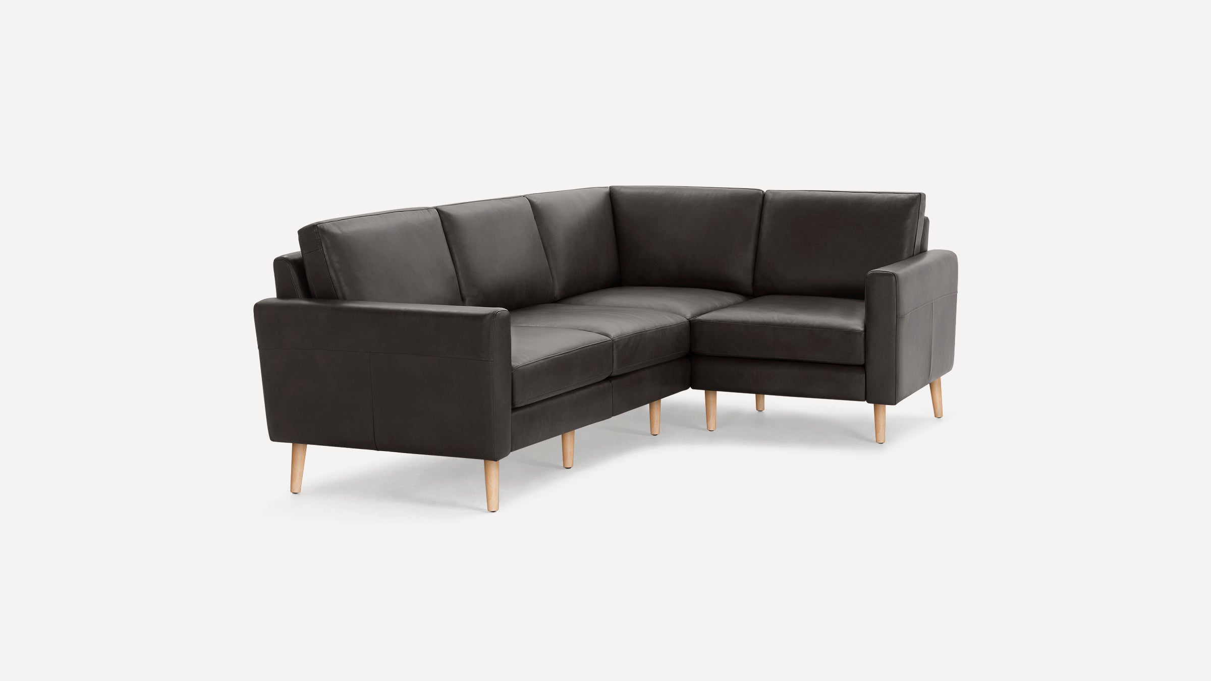 Dark gray L-shaped leather sectional sofa with light wooden legs, featuring clean lines and a modern minimalist design.