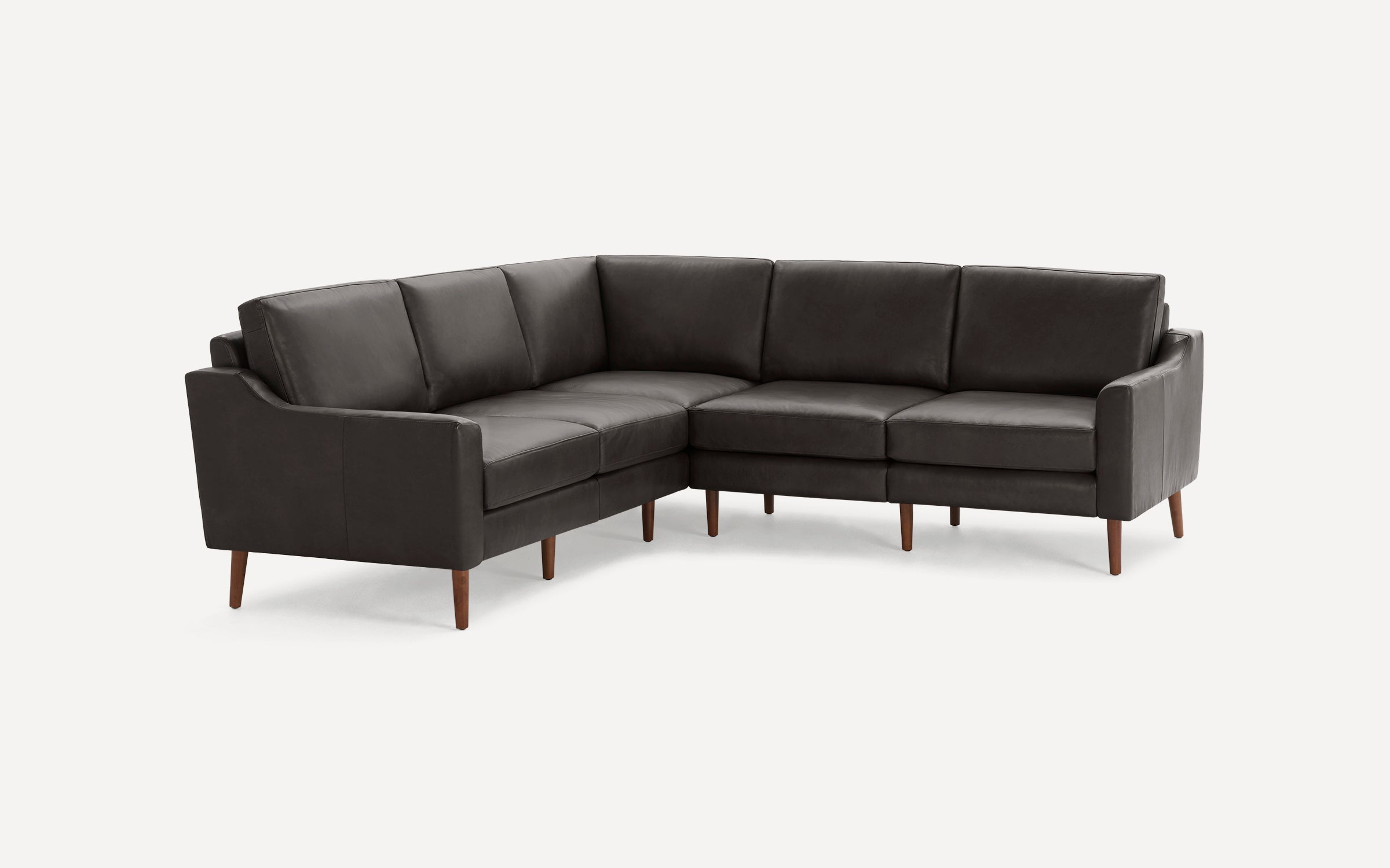 Dark brown leather sectional sofa with wooden tapered legs and cushioned seats and backs, designed in a modern style.