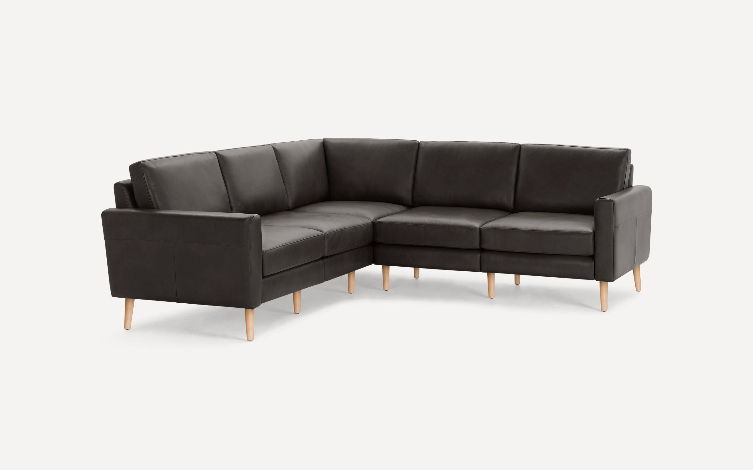 Modern dark gray sectional sofa with clean lines, cushioned seats, and light wooden legs on white background.