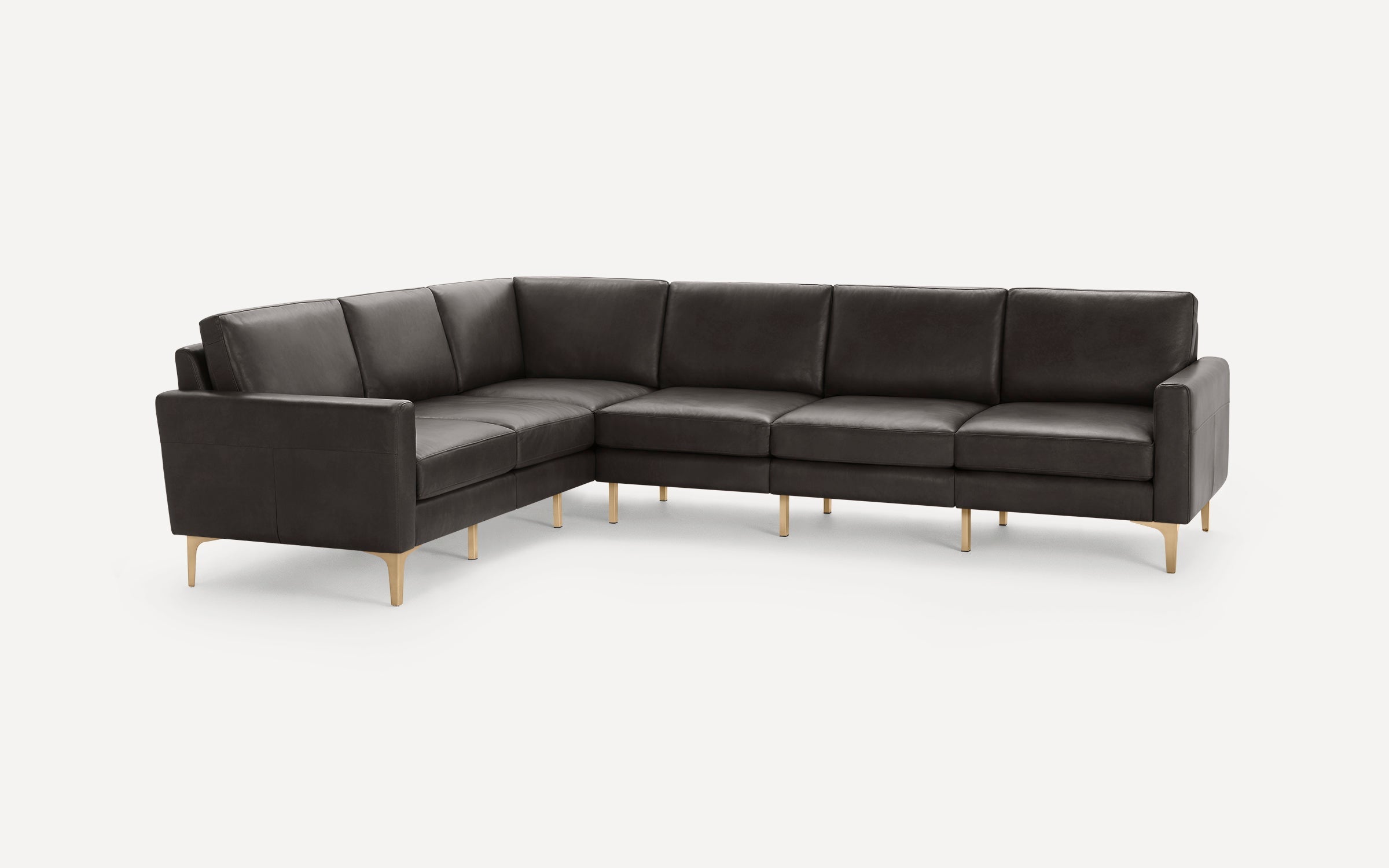 Dark gray leather sectional sofa with sleek design, cushioned seats, and slender gold metal legs on a white background.