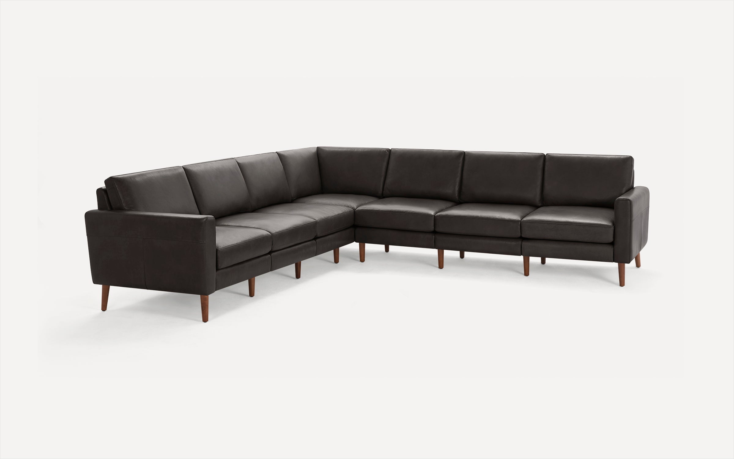 Dark gray leather sectional sofa with wooden tapered legs and cushioned seats and backs, set against a plain white background.