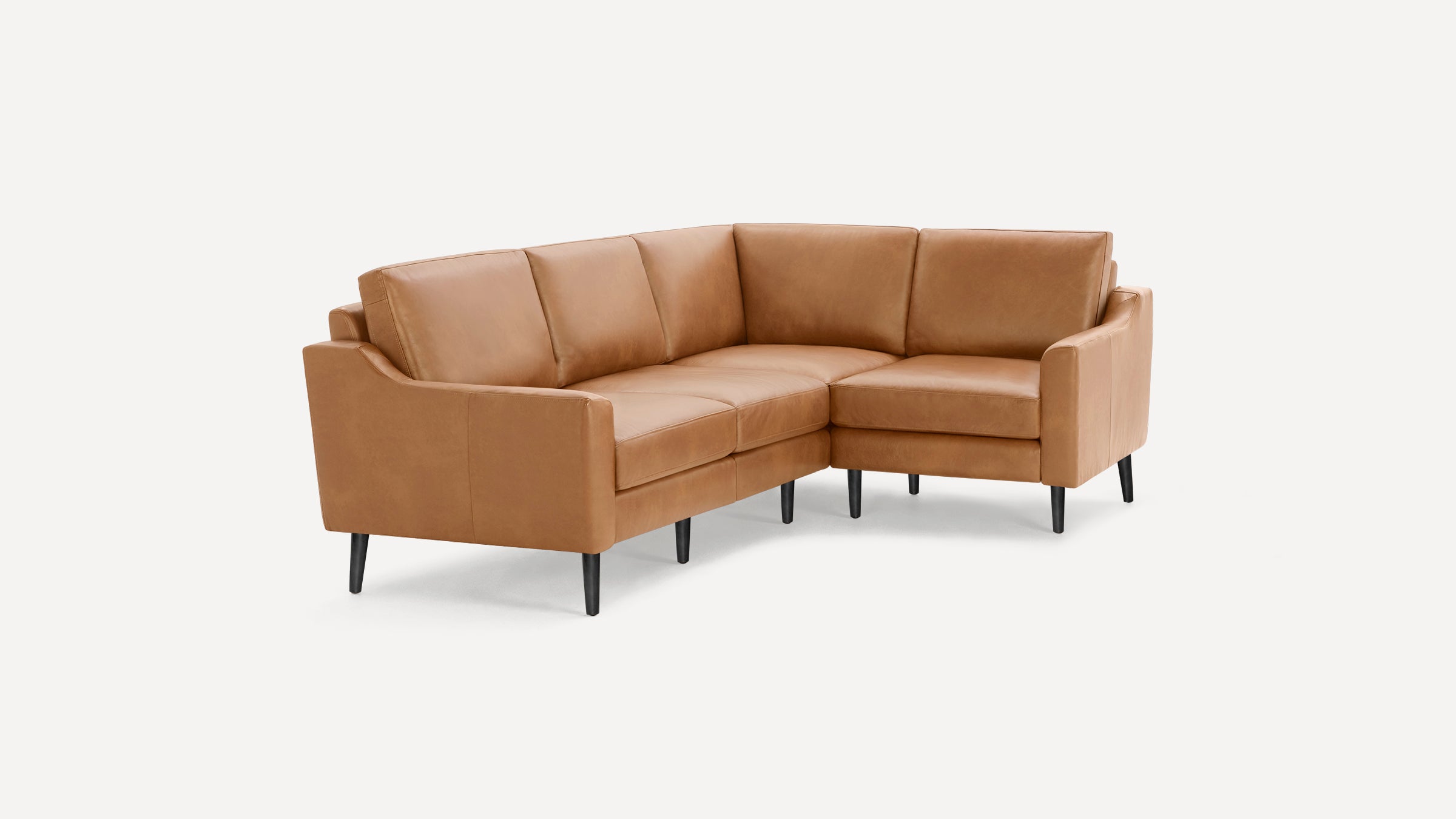Mid-century modern tan leather sectional sofa with black tapered legs and clean, straight lines on white background.