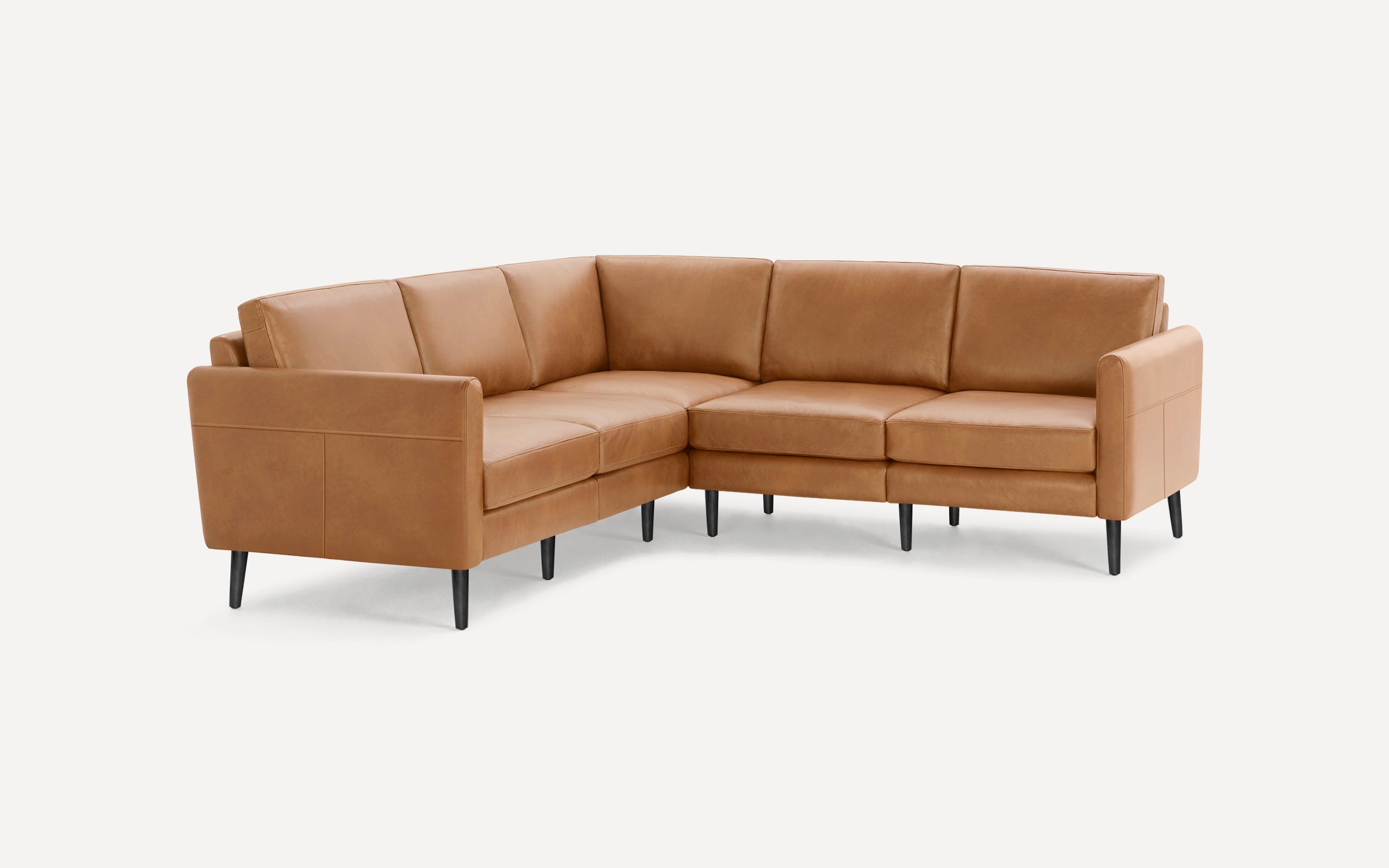 Modern L-shaped sectional sofa in tan leather with clean lines and black tapered legs against white background.