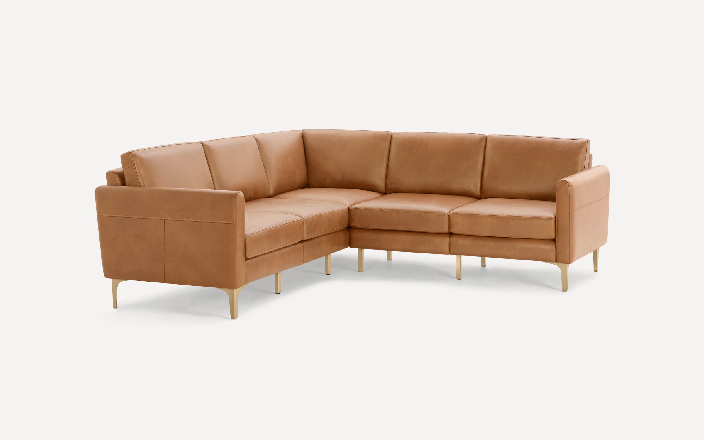 Modern L-shaped tan leather sectional sofa with clean lines, cushioned seats, and slim brass-colored legs on white background.