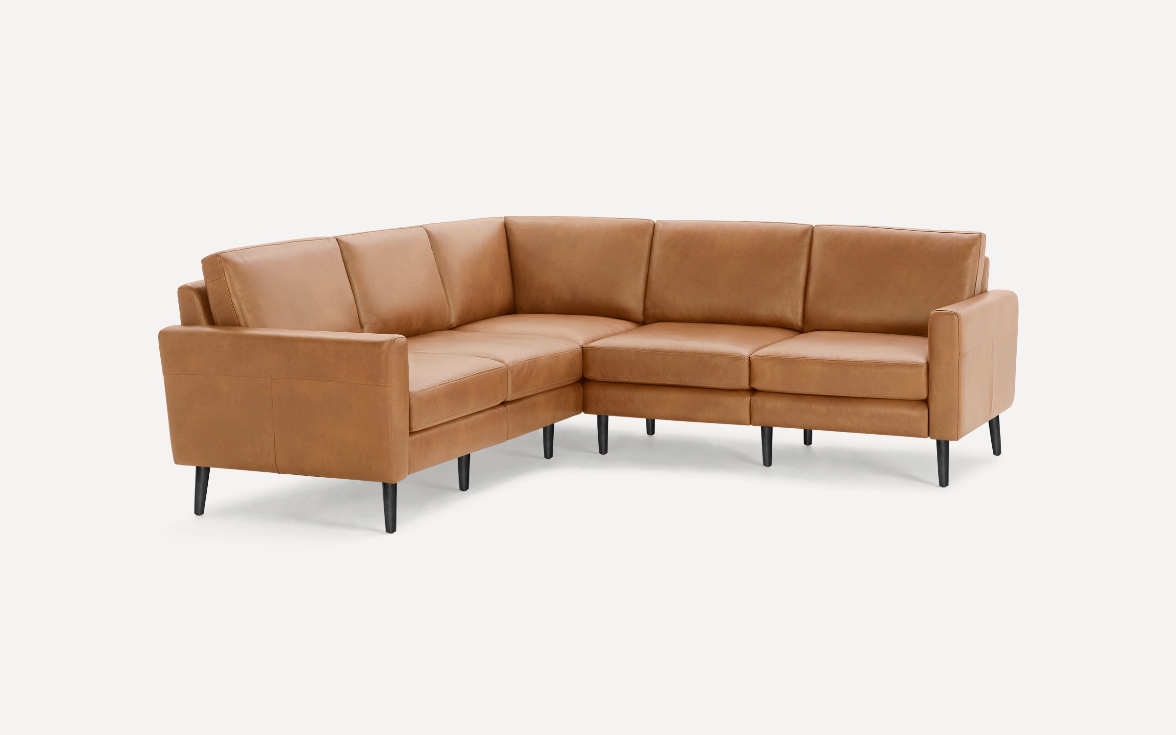 Modern L-shaped sectional sofa with tan leather upholstery and black tapered wooden legs, clean lines, and plush cushions.