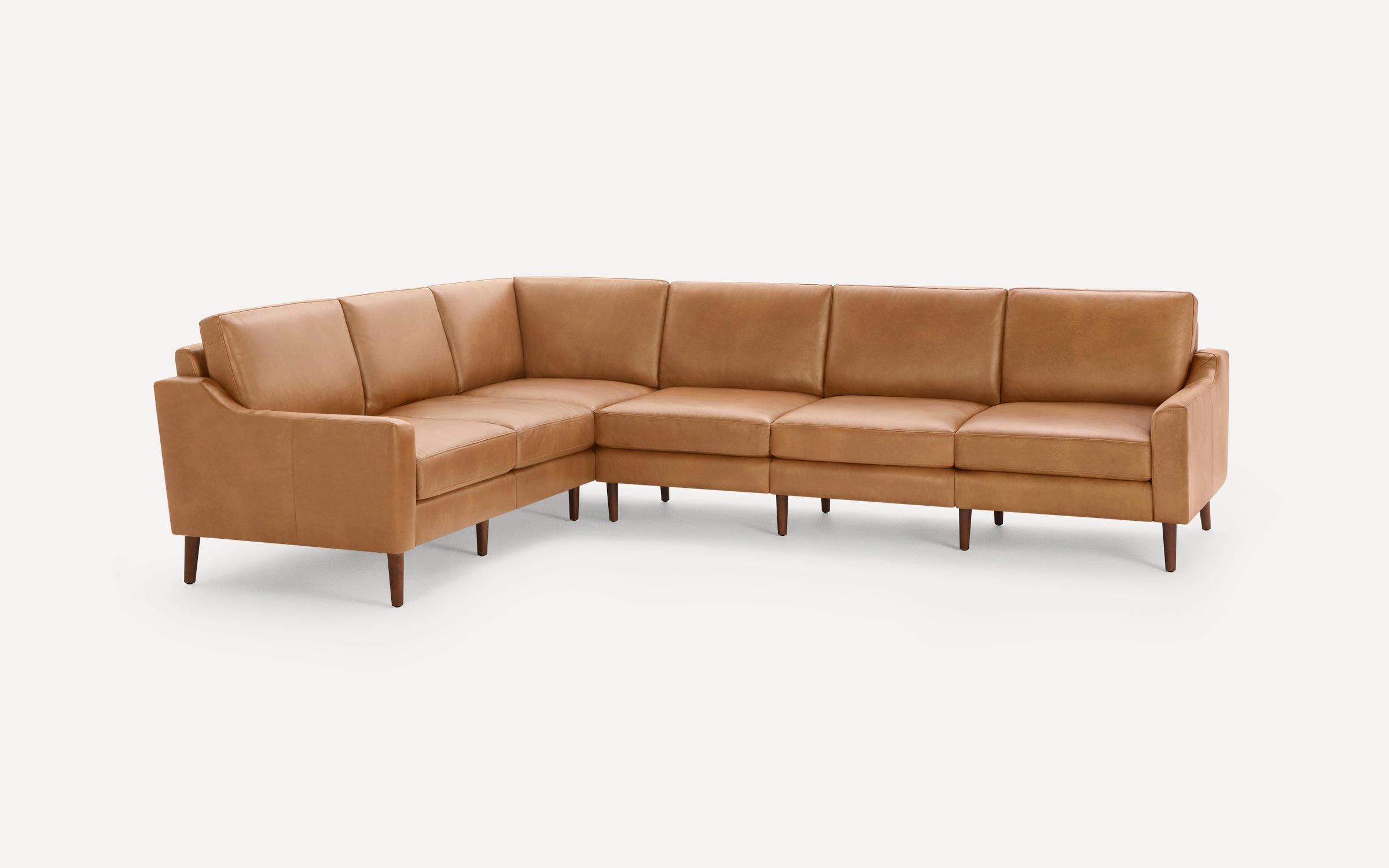 Mid-century modern L-shaped sectional sofa in light brown leather with wooden tapered legs and cushioned seats.