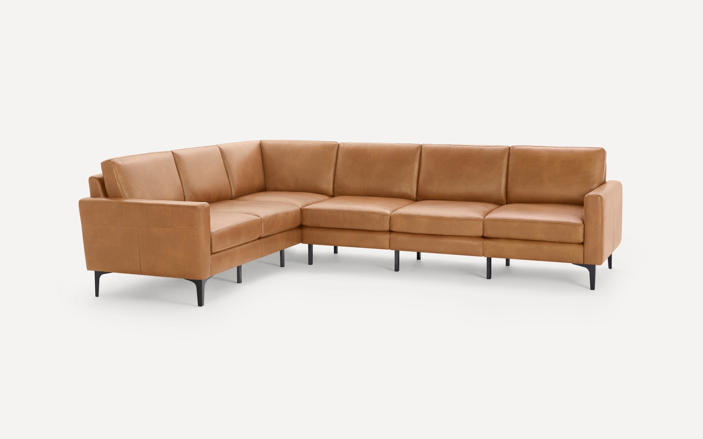 Modern L-shaped sectional sofa upholstered in tan leather with slim black metal legs, featuring cushioned seats and backrests.