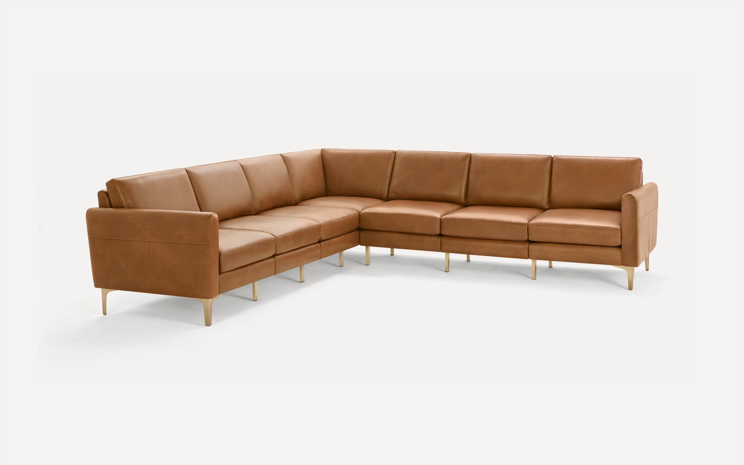 Modern L-shaped sectional sofa in tan leather with slim gold metal legs, clean lines, and cushioned seats and backrests.
