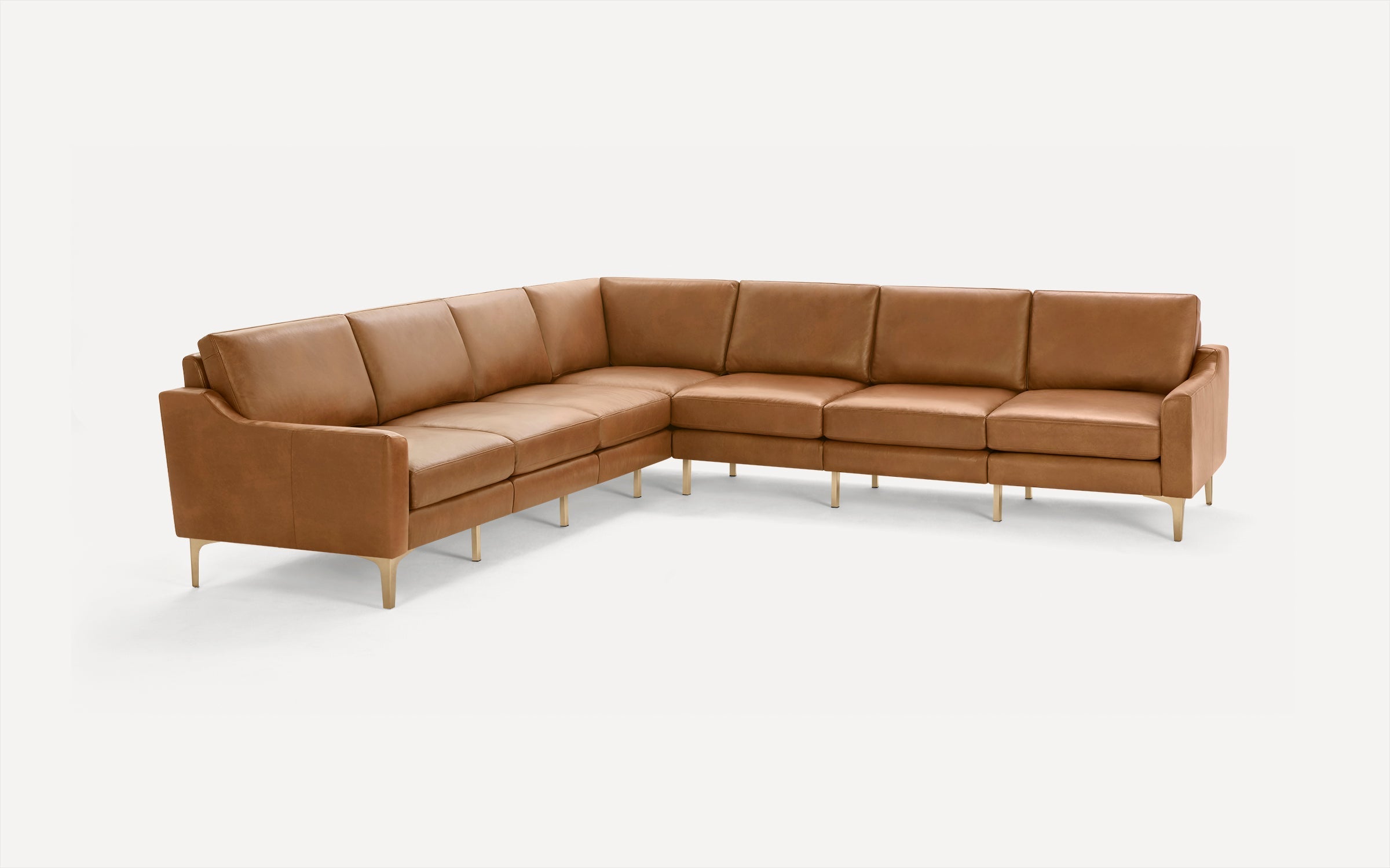Modern L-shaped sectional sofa upholstered in tan leather with slim, light wood legs and cushioned seating and backrests.