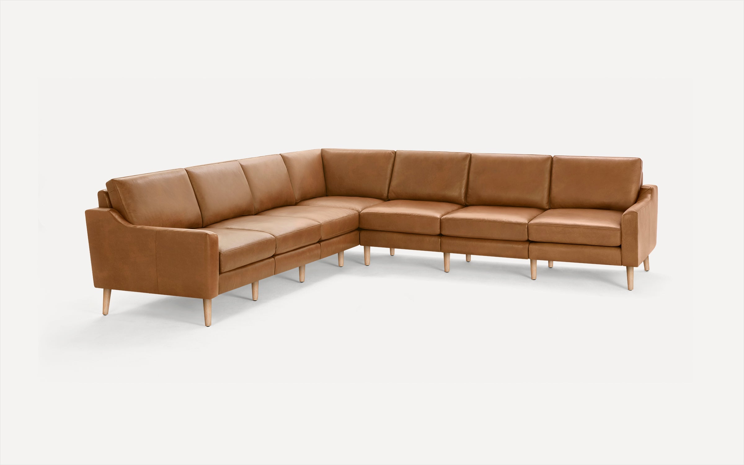 Modern L-shaped sectional sofa with smooth light brown leather upholstery and light wooden tapered legs on a plain white background.
