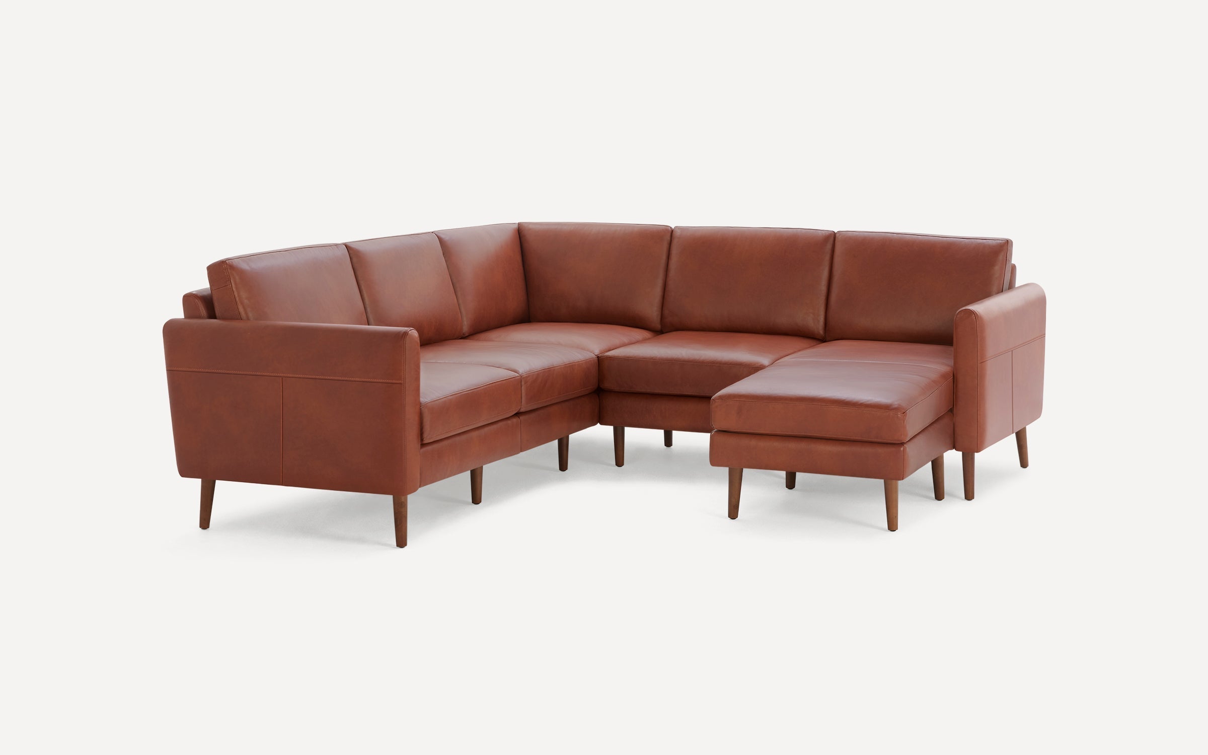 Modern mid-century style brown leather sectional sofa with wooden legs and clean lines, designed for spacious seating.