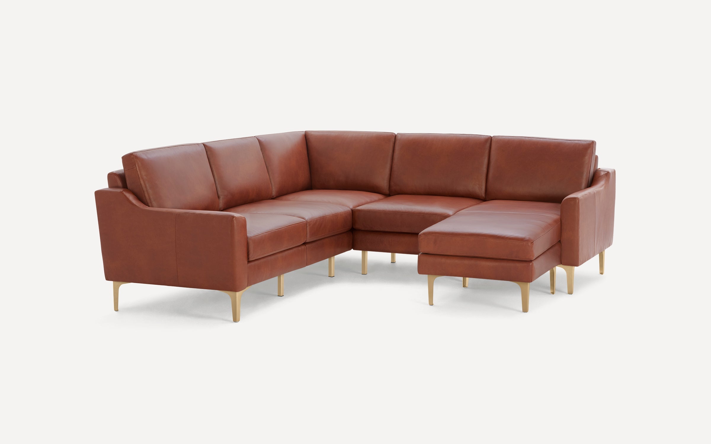 Modern brown leather sectional sofa with gold metal legs, featuring a chaise lounge on the right side, on a white background.