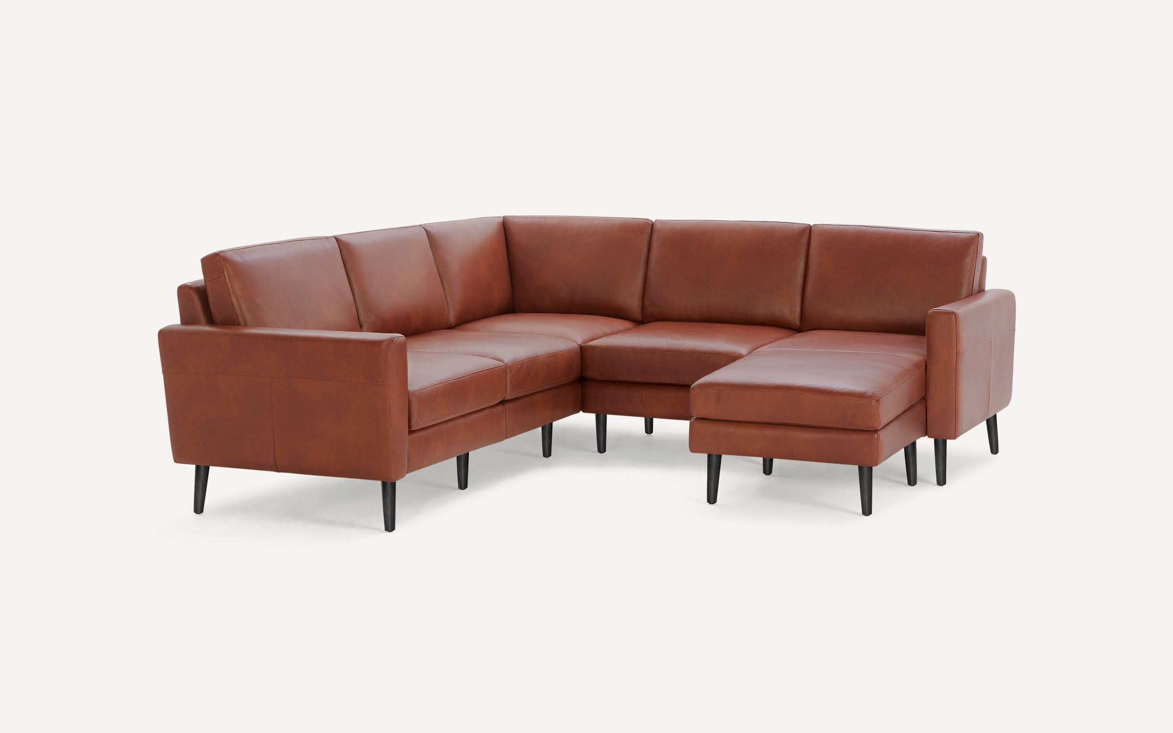 Brown leather L-shaped sectional sofa with black tapered legs and cushioned seats and backrests, shown on a white background.