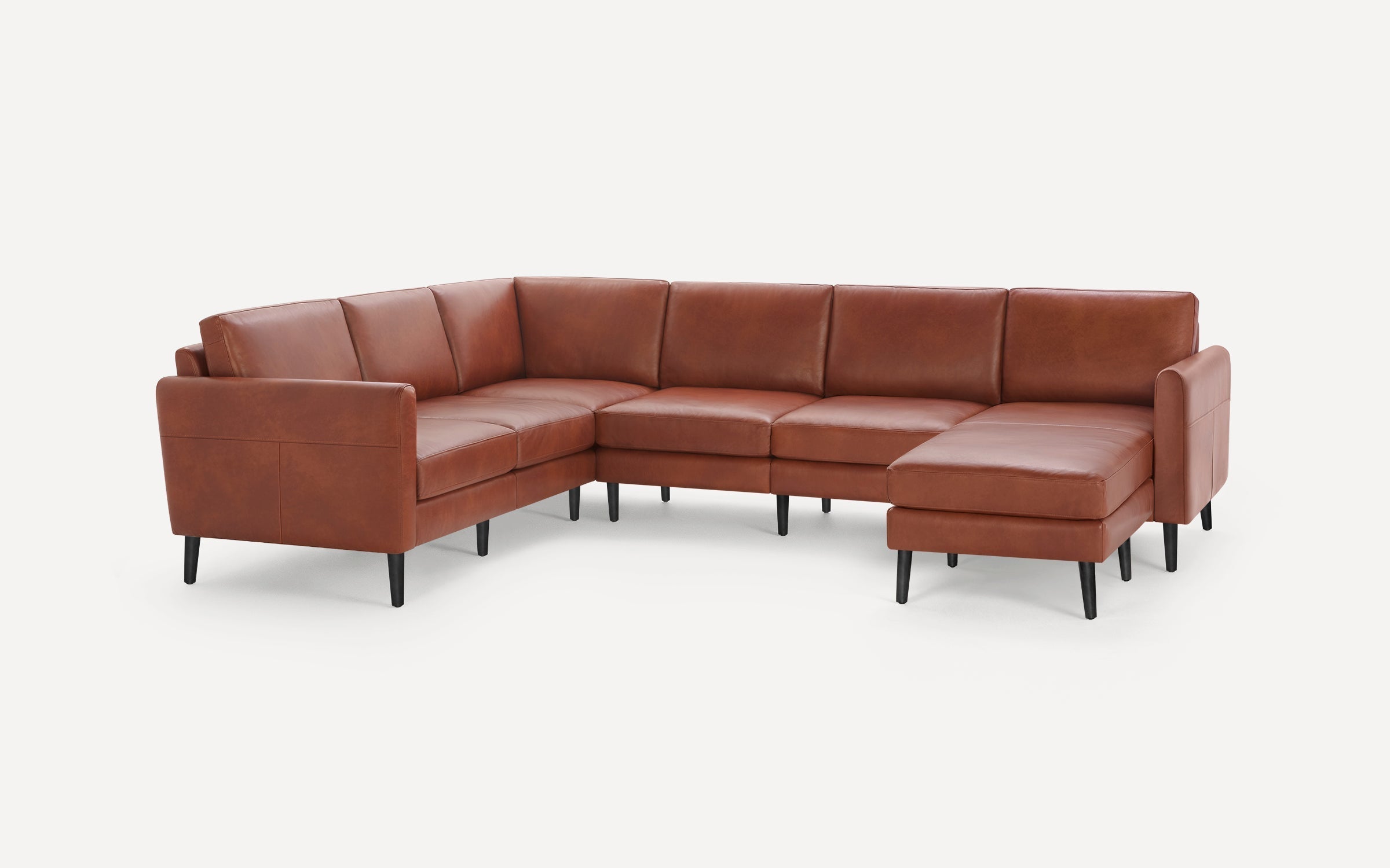 Large L-shaped sectional sofa upholstered in rich brown leather with sleek black tapered legs and clean modern design.
