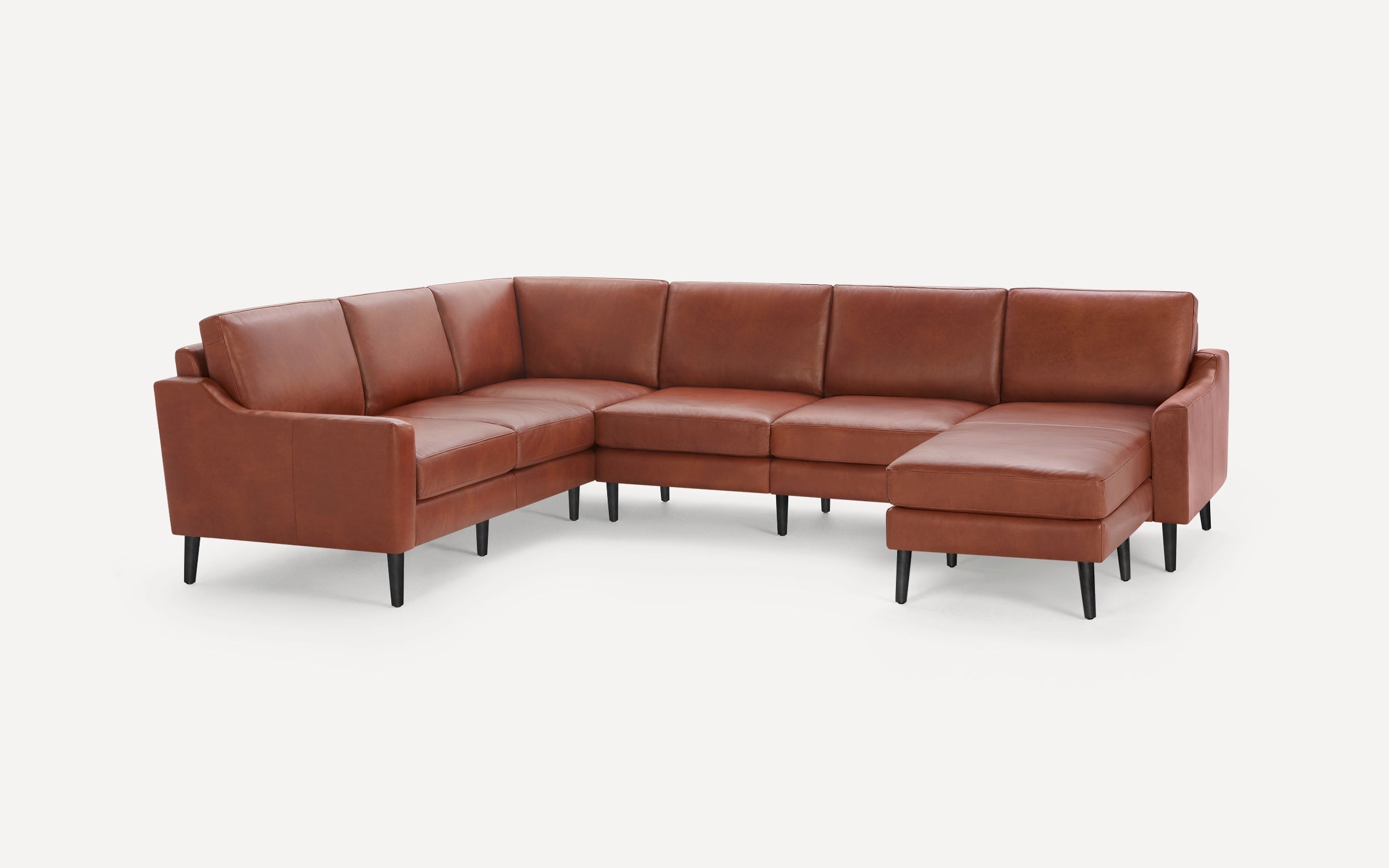 Brown leather L-shaped sectional sofa with clean lines, plush cushions, and black tapered wooden legs on white background.
