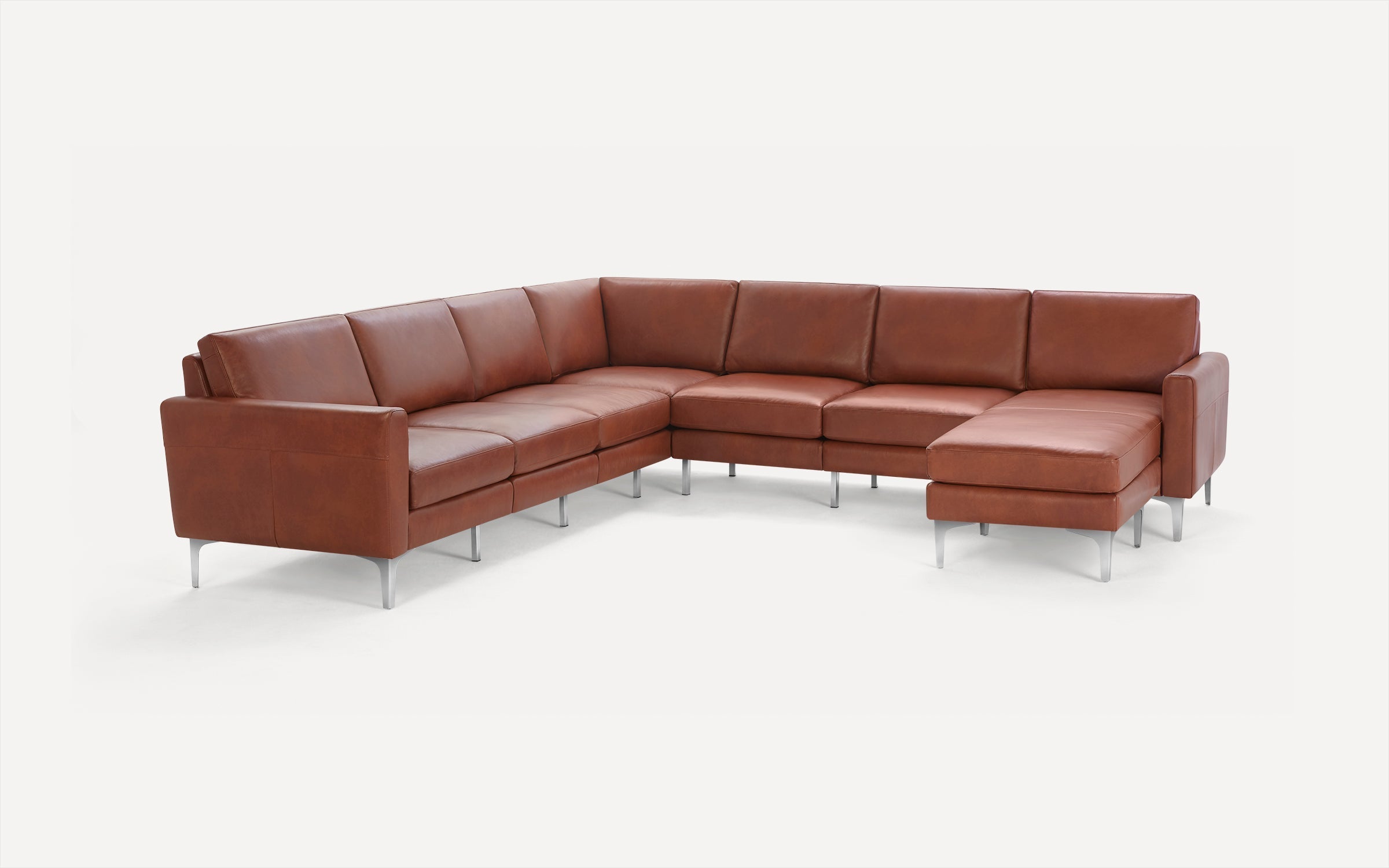 Modern L-shaped sectional sofa with rich brown leather upholstery and sleek metal legs, featuring a chaise lounge on the right side.