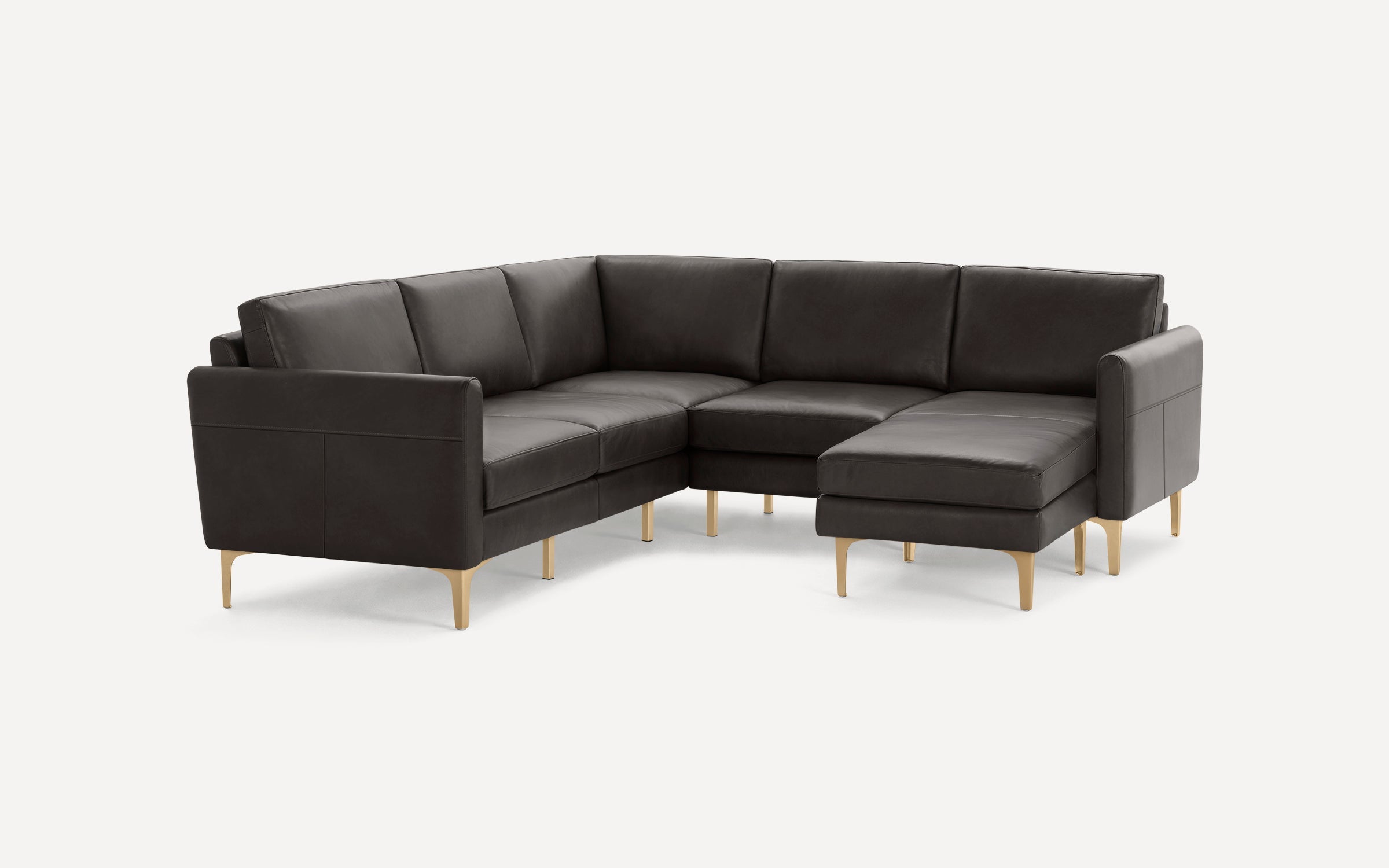 Dark gray L-shaped sectional sofa with sleek armrests and gold tapered legs, upholstered in smooth leather.