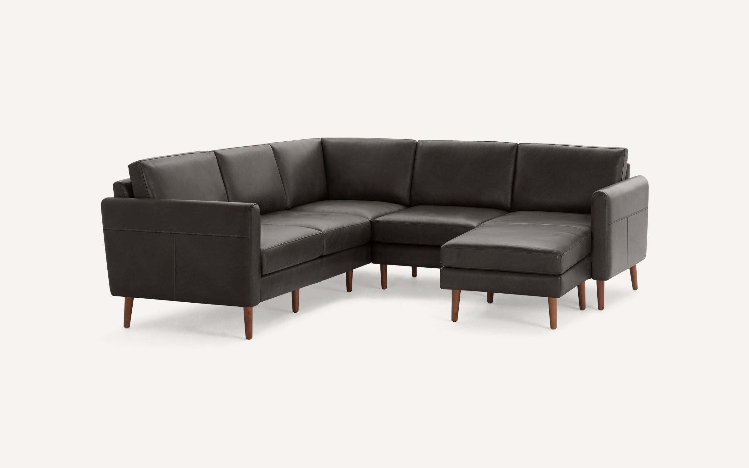 Dark gray leather sectional sofa with wooden legs, featuring an L-shaped design and cushioned seating and backrests.