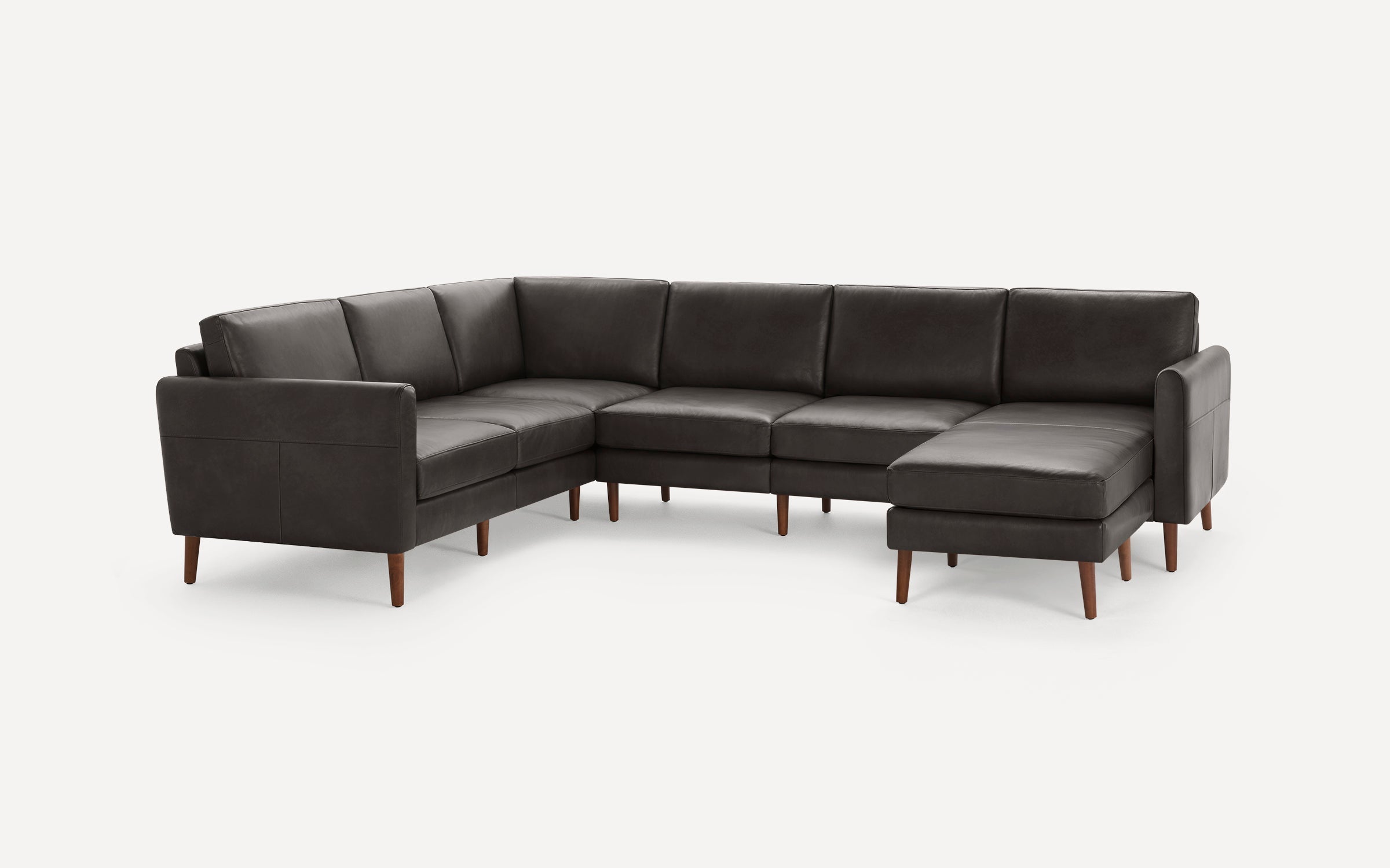 Modern dark gray leather sectional sofa with wooden legs, featuring an L-shaped design and cushioned seating.