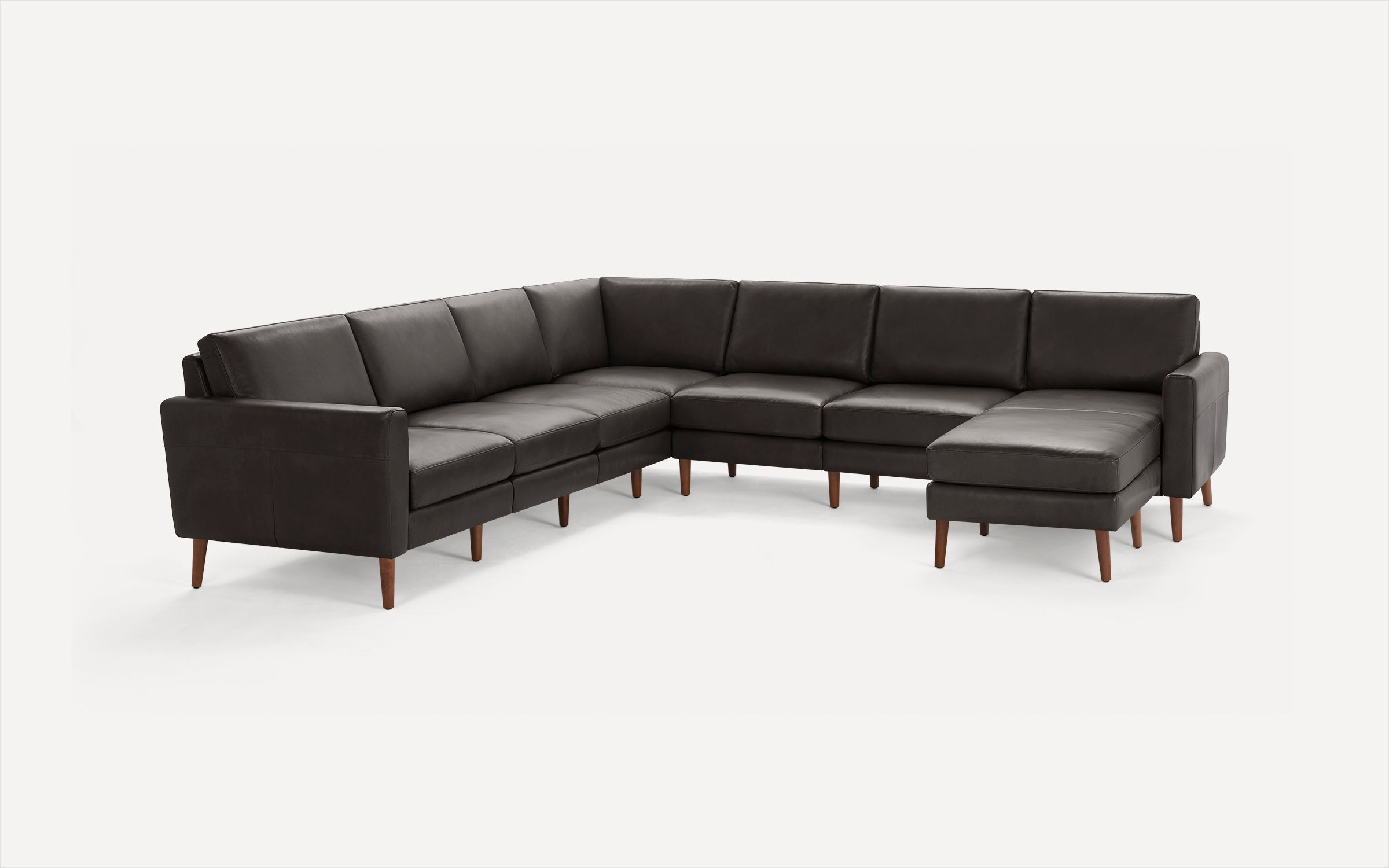 L-shaped modern sectional sofa in dark gray leather with wooden tapered legs and cushioned seats and backs.