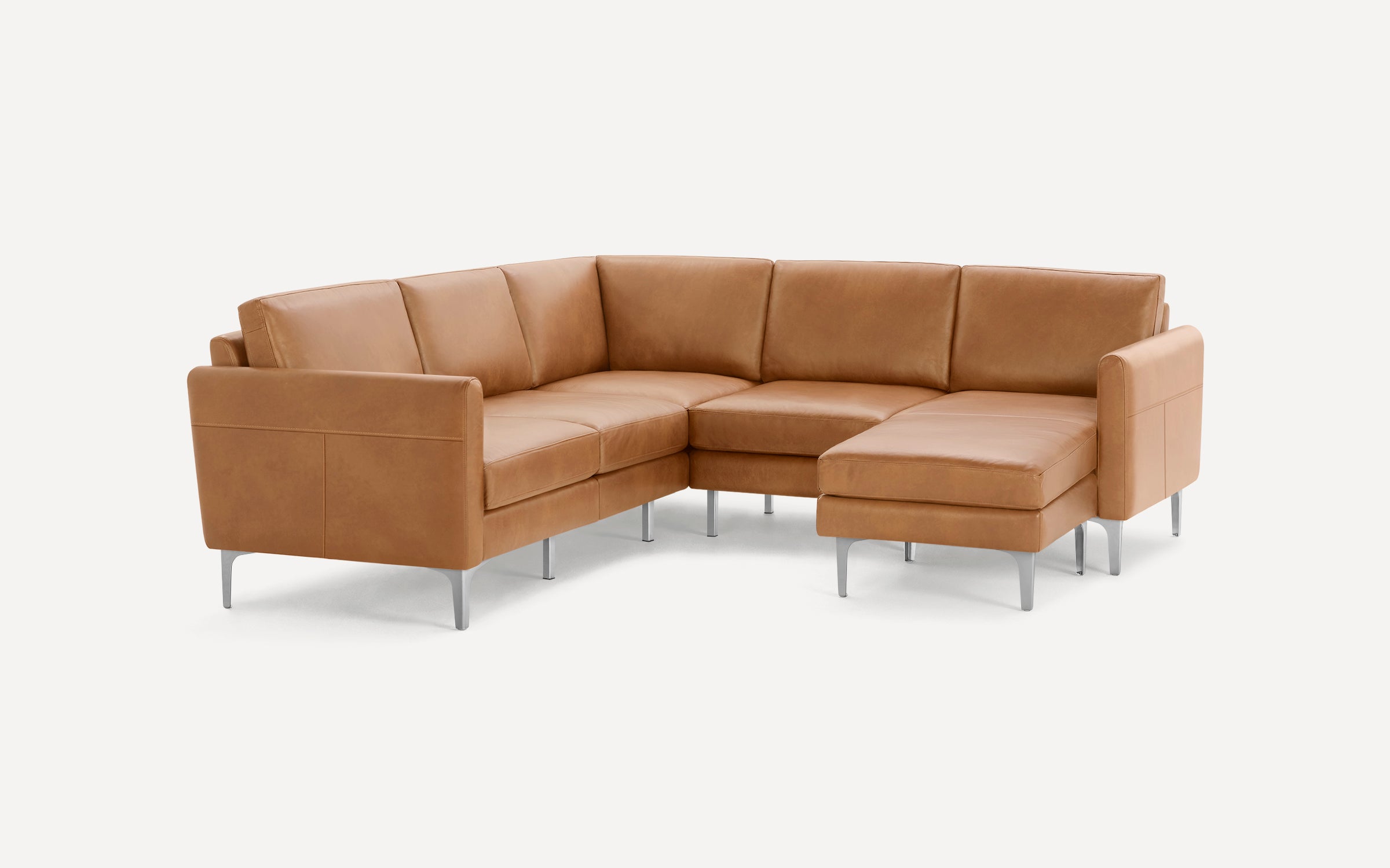 Modern L-shaped sectional sofa in light brown leather with slim metal legs and clean lines against white background.