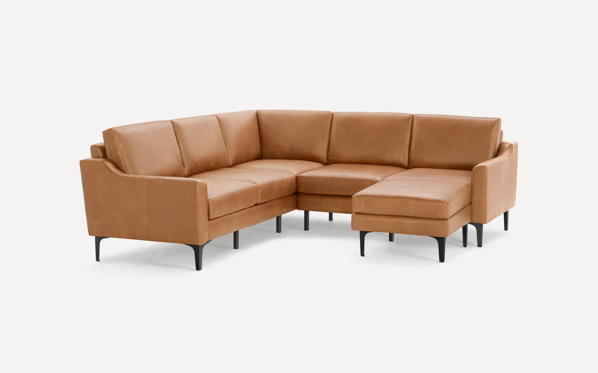 Modern L-shaped sectional sofa in tan leather with slim black legs and clean, smooth cushions on all sides.