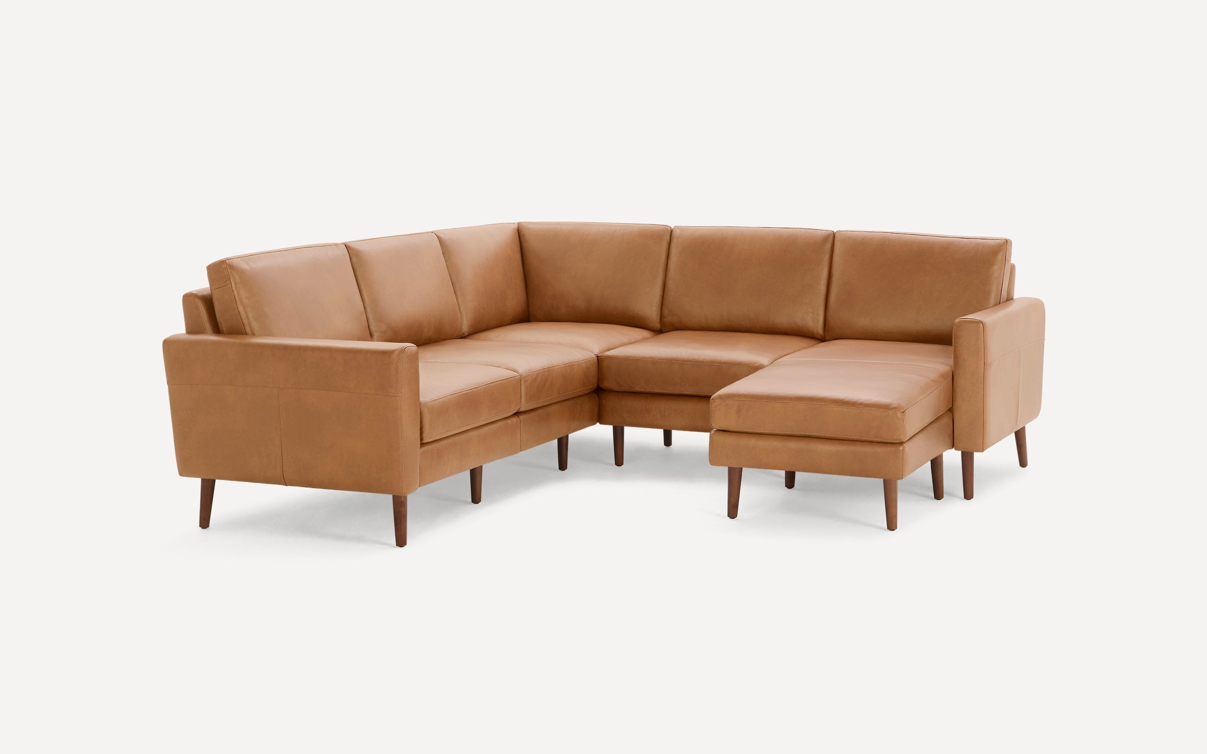 Modern L-shaped sectional sofa in tan leather upholstery with cushioned seats, backrests, and wooden tapered legs.
