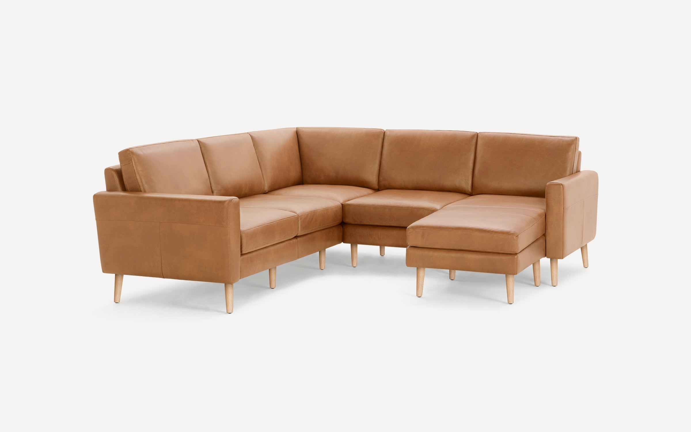 Tan brown leather sectional sofa with wooden tapered legs and a right-side chaise lounge, modern minimalist design.