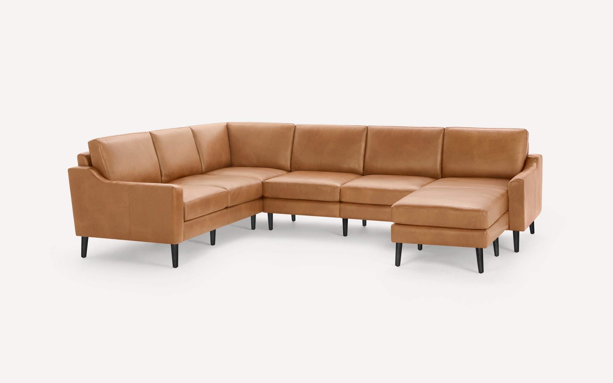 Modern L-shaped sectional sofa in tan leather with clean lines, cushioned seats, backrests, and black tapered legs.