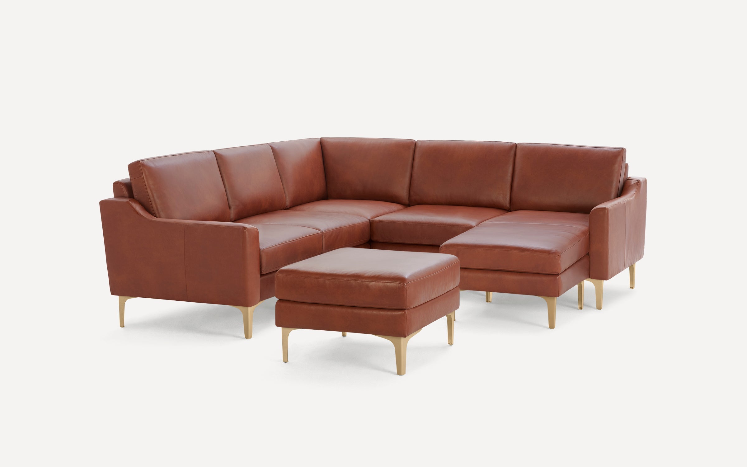 Modern L-shaped sectional sofa in rich brown leather with matching ottoman and sleek gold metal legs.