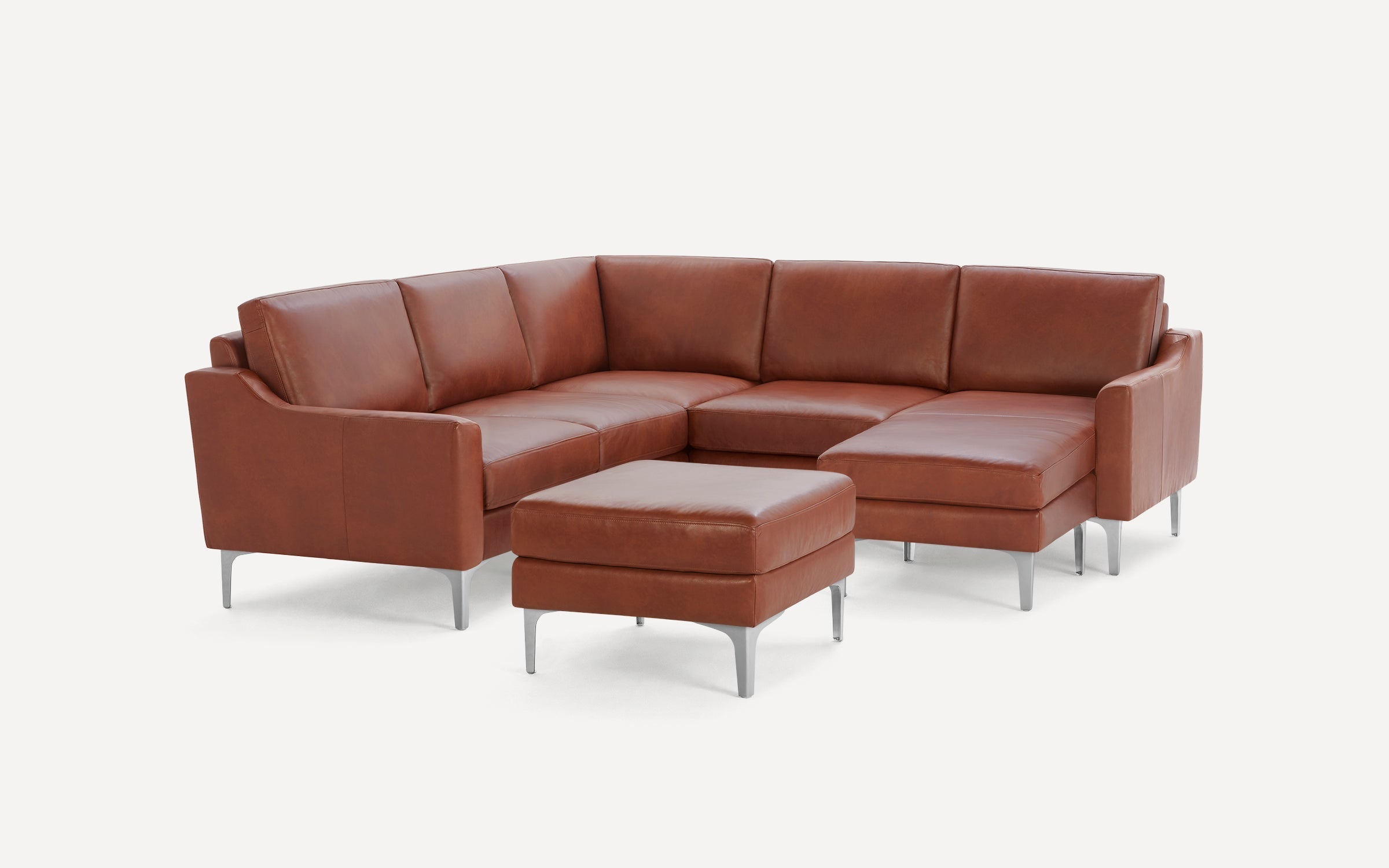 Modern brown leather sectional sofa with sleek metal legs and matching ottoman, designed for spacious, stylish living rooms.