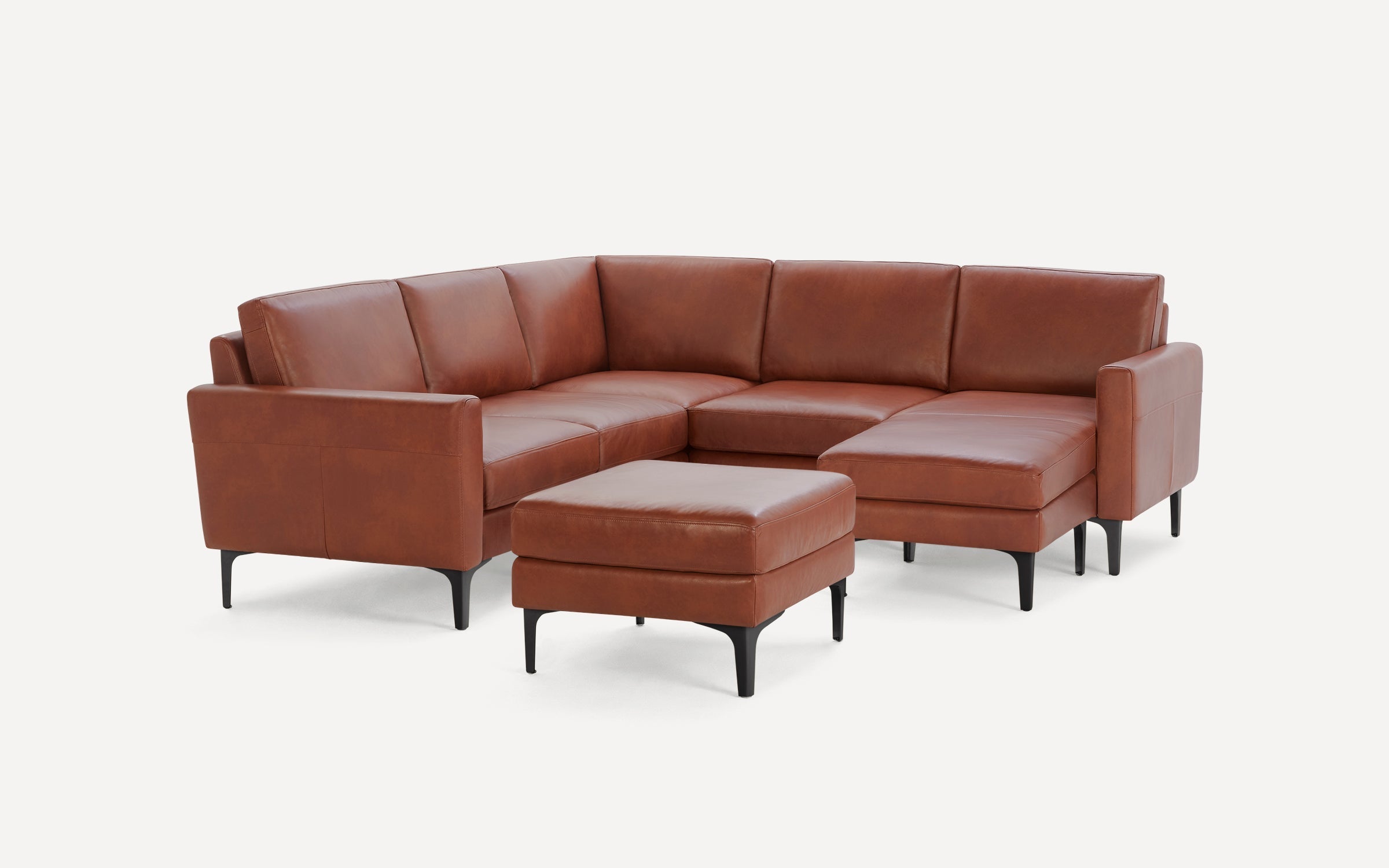 Brown leather sectional sofa with a matching ottoman, featuring black slender legs and clean, modern design.