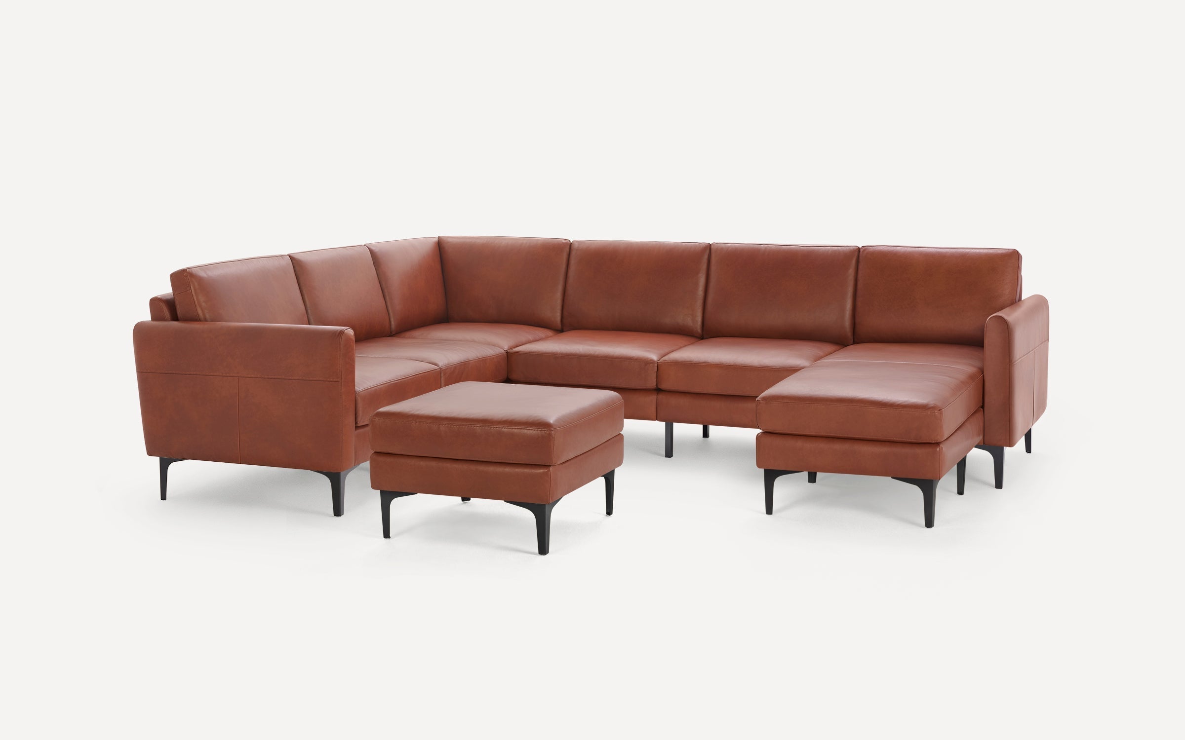 Brown leather sectional sofa with black legs, including a matching ottoman, shown on a white background.