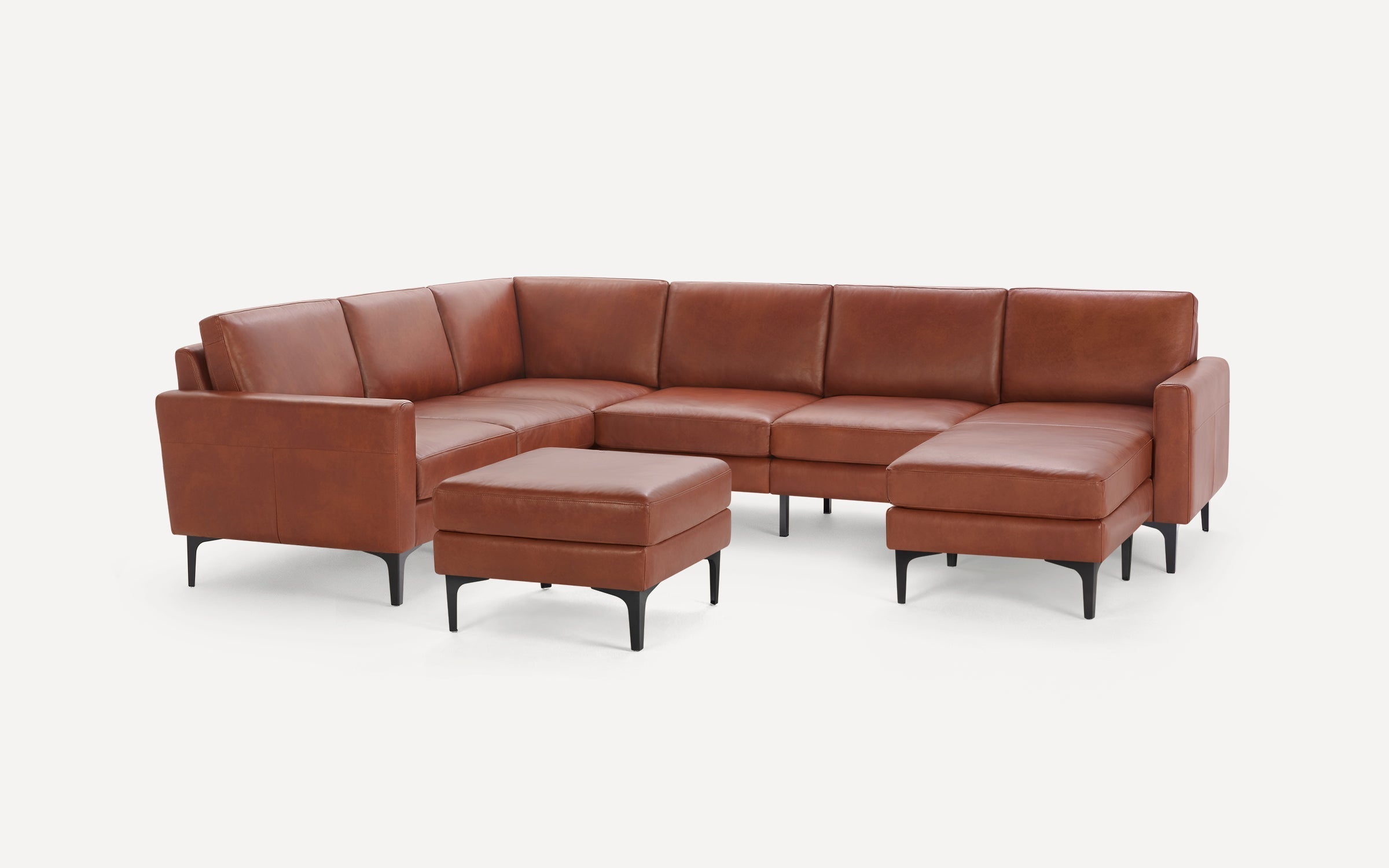 Brown leather sectional sofa with matching ottoman, featuring clean lines and black tapered legs, ideal for modern living rooms.