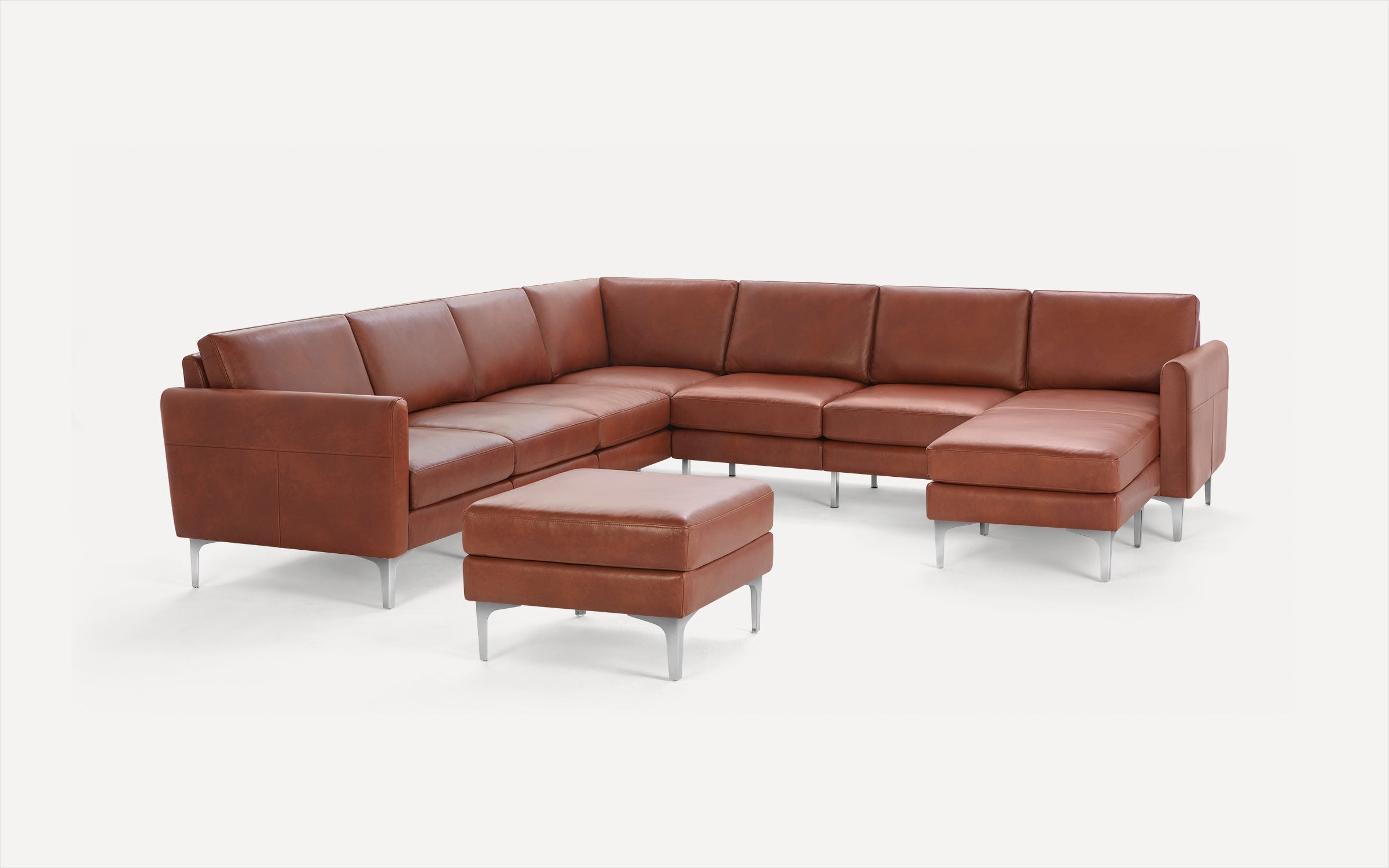 Modern brown leather sectional sofa with metal legs and matching ottoman, designed for spacious seating and comfort.