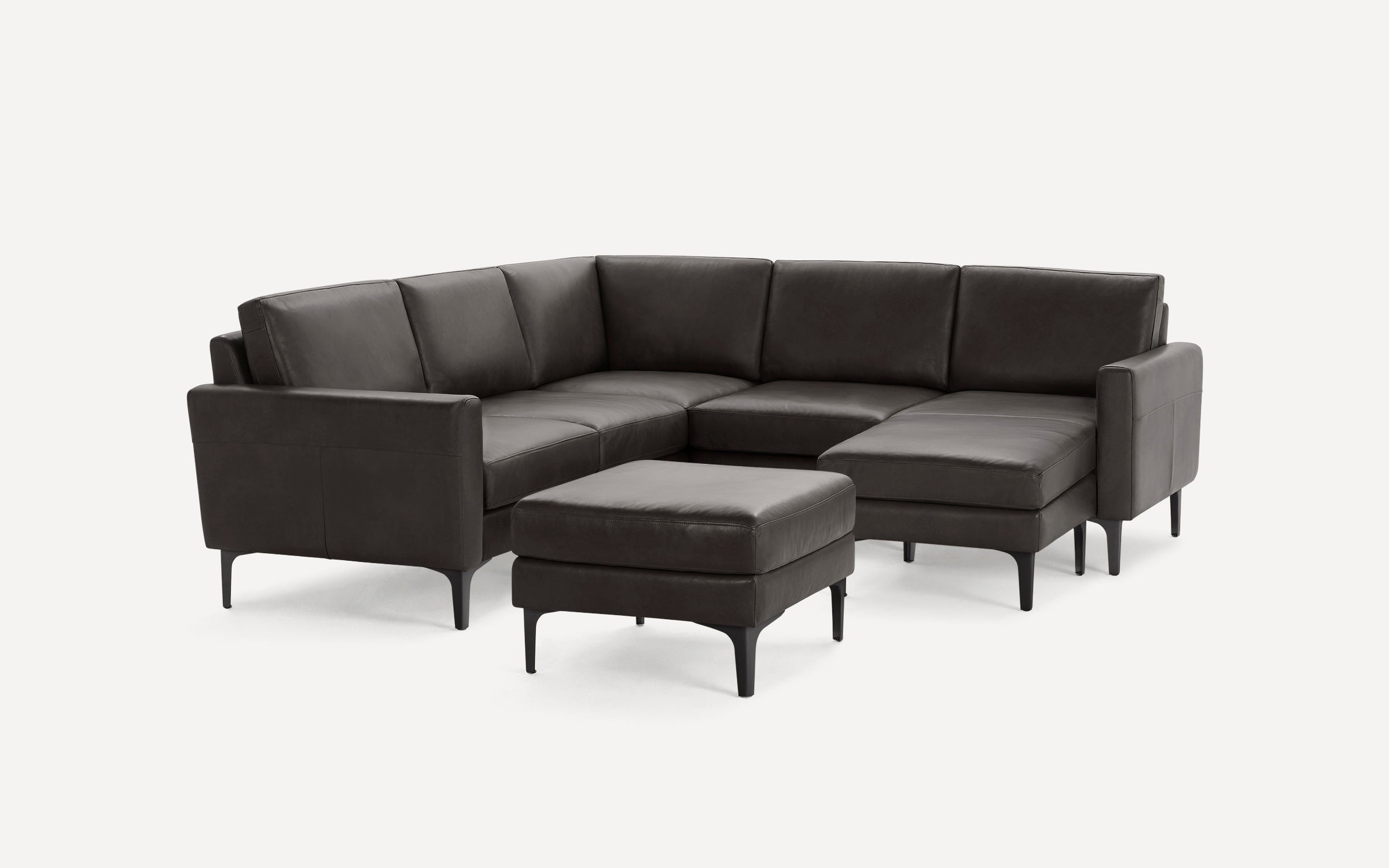 Dark brown leather sectional sofa with modern design, featuring an ottoman and slim black legs, set against a plain white background.