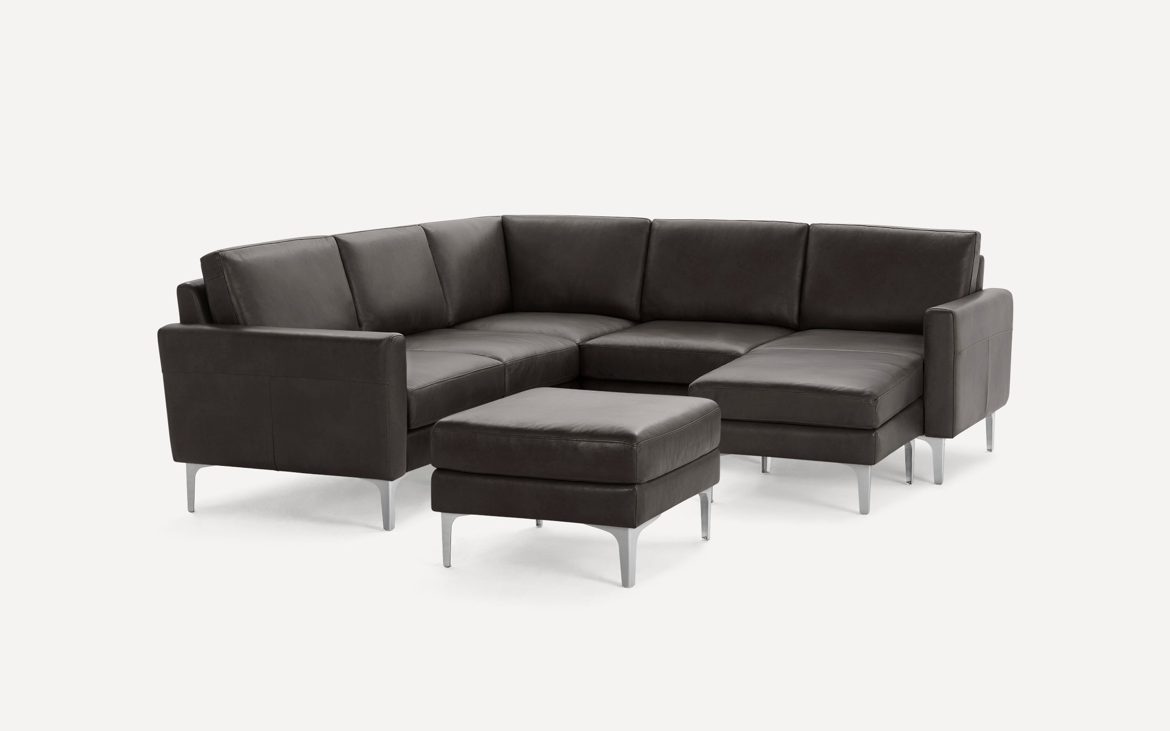 Modern dark gray leather sectional sofa with clean lines and silver metal legs, paired with a matching ottoman.