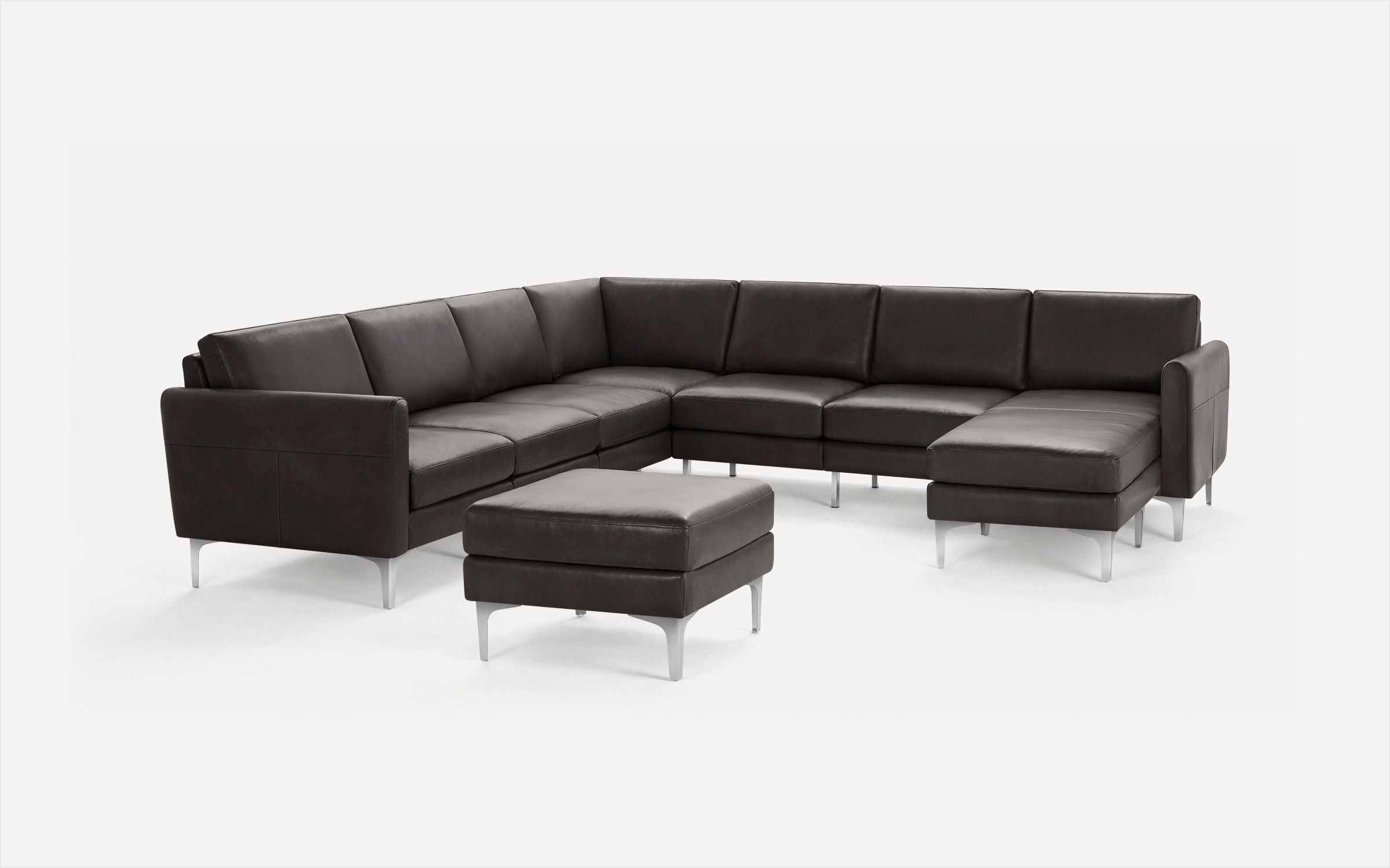 Dark brown leather sectional sofa with matching ottoman, clean lines, and silver metal legs on a white background.