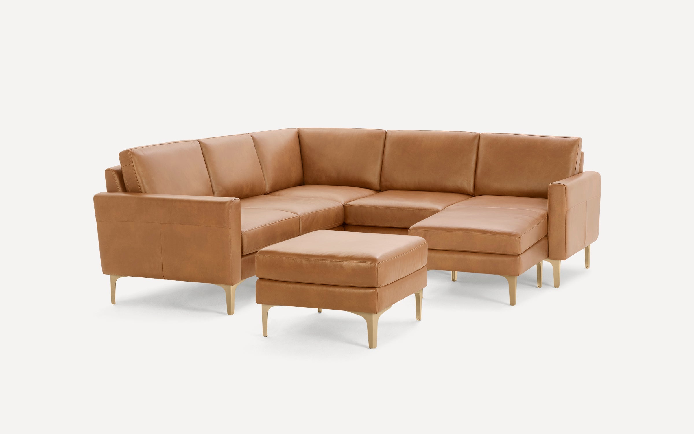 Modern tan leather sectional sofa with clean lines, metal legs, and a matching ottoman on a white background.