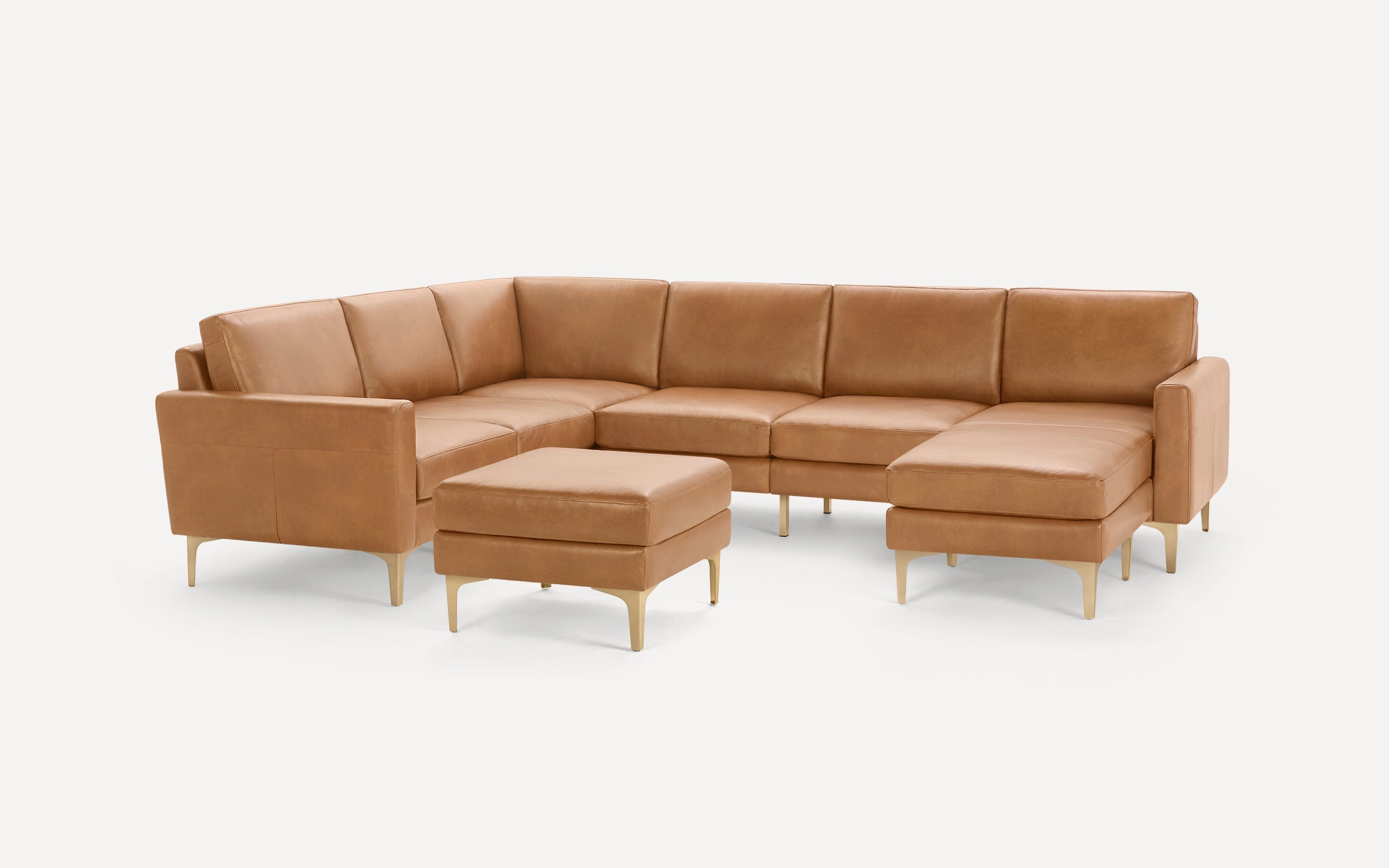 Tan leather L-shaped sectional sofa with cushioned seats and backrests, paired with a matching square ottoman.