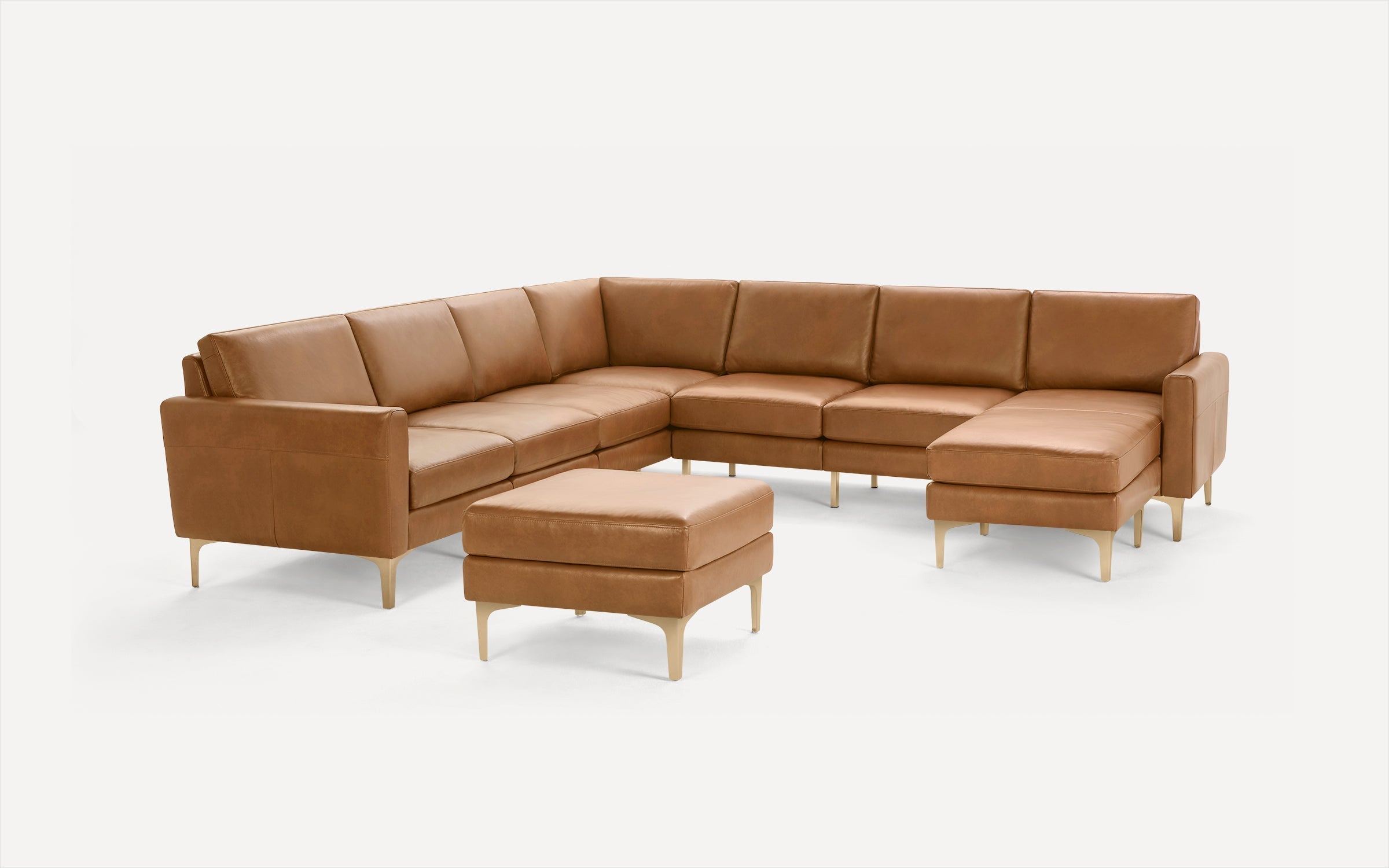 Modern L-shaped sectional sofa in tan leather with matching ottoman, featuring wooden legs and clean, minimalist design.