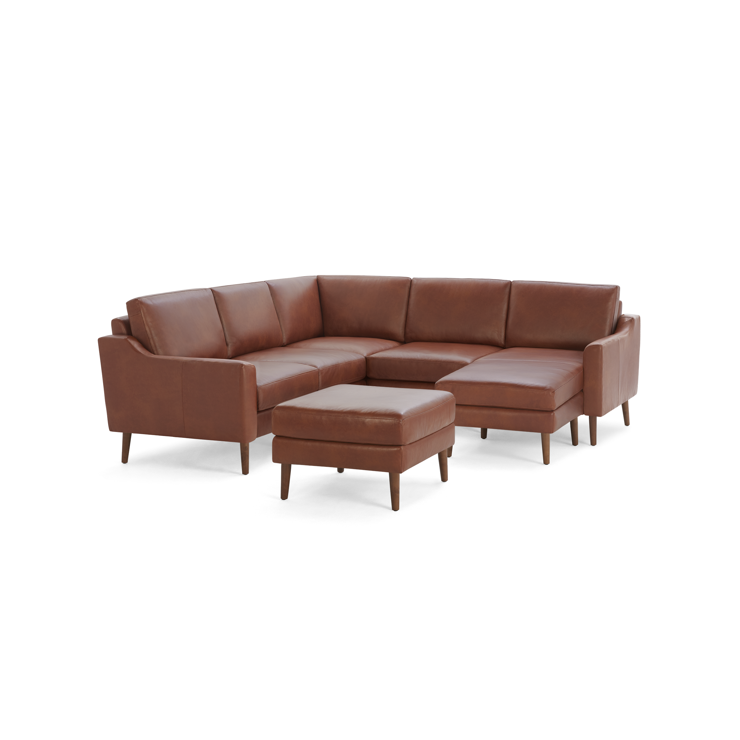 Brown leather L-shaped sectional sofa with matching ottoman and wooden legs on a black background.