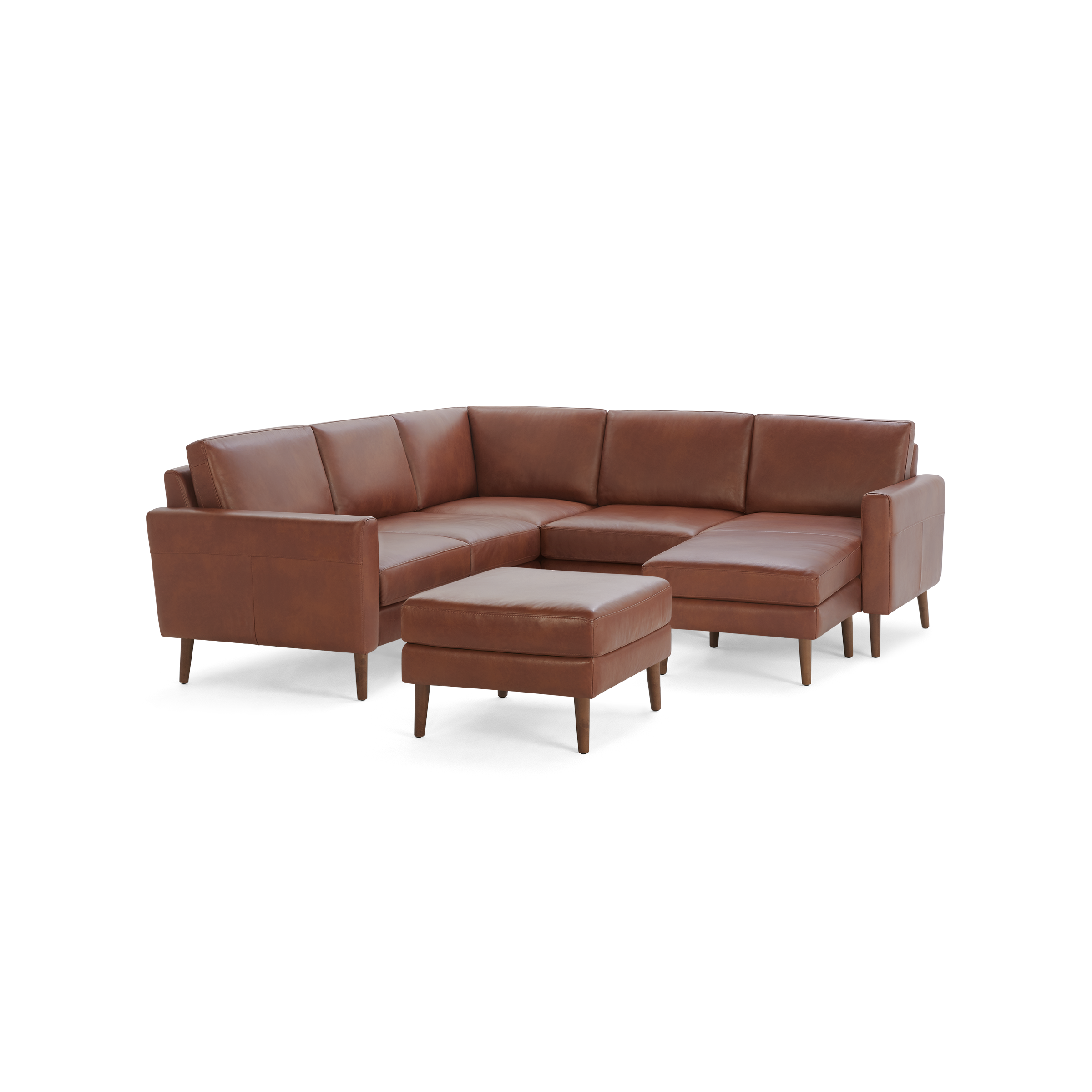 Modern brown leather sectional sofa with wooden legs and a matching ottoman, offering spacious seating and clean lines.