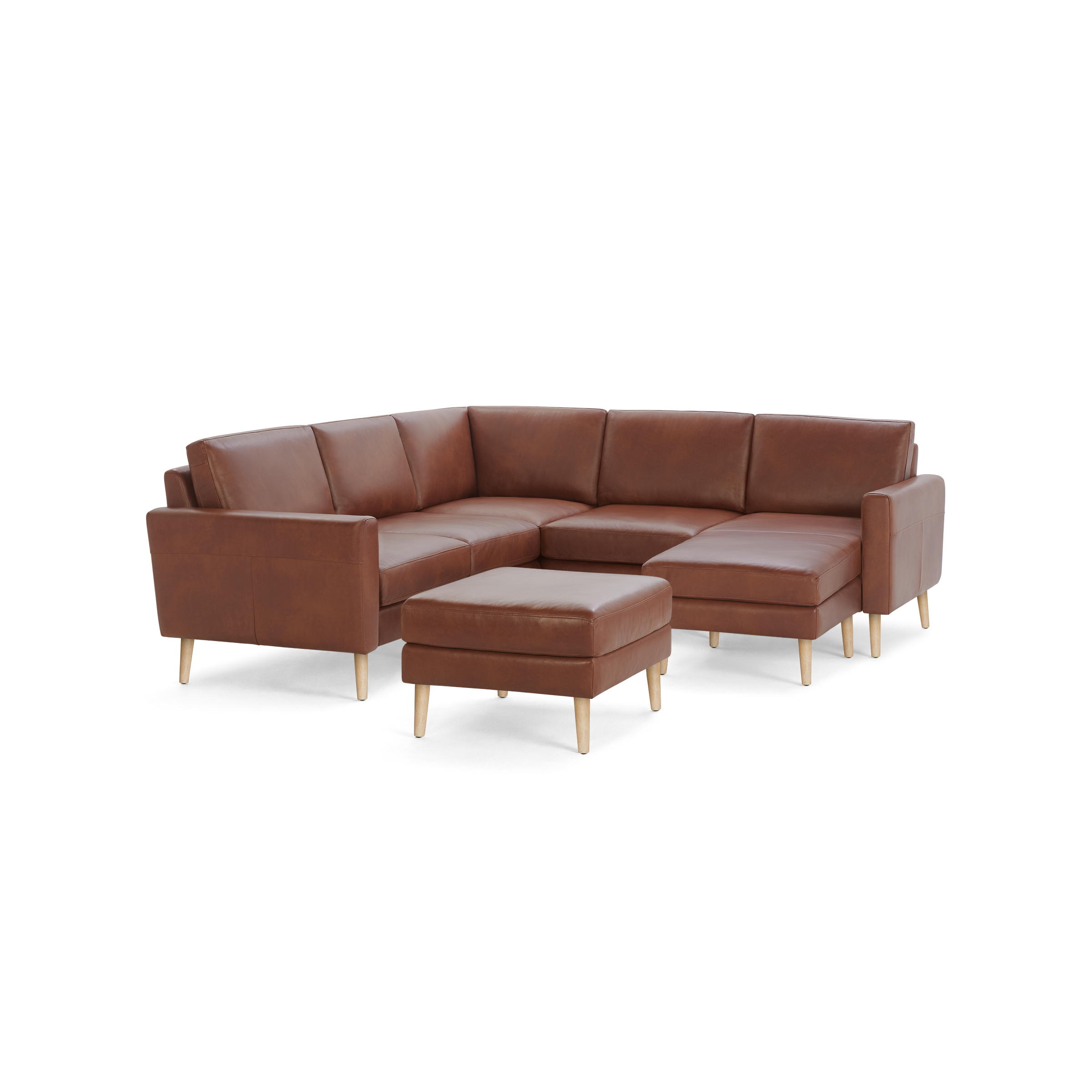 Brown leather L-shaped sectional sofa with wooden legs and matching ottoman, featuring clean lines and modern design.