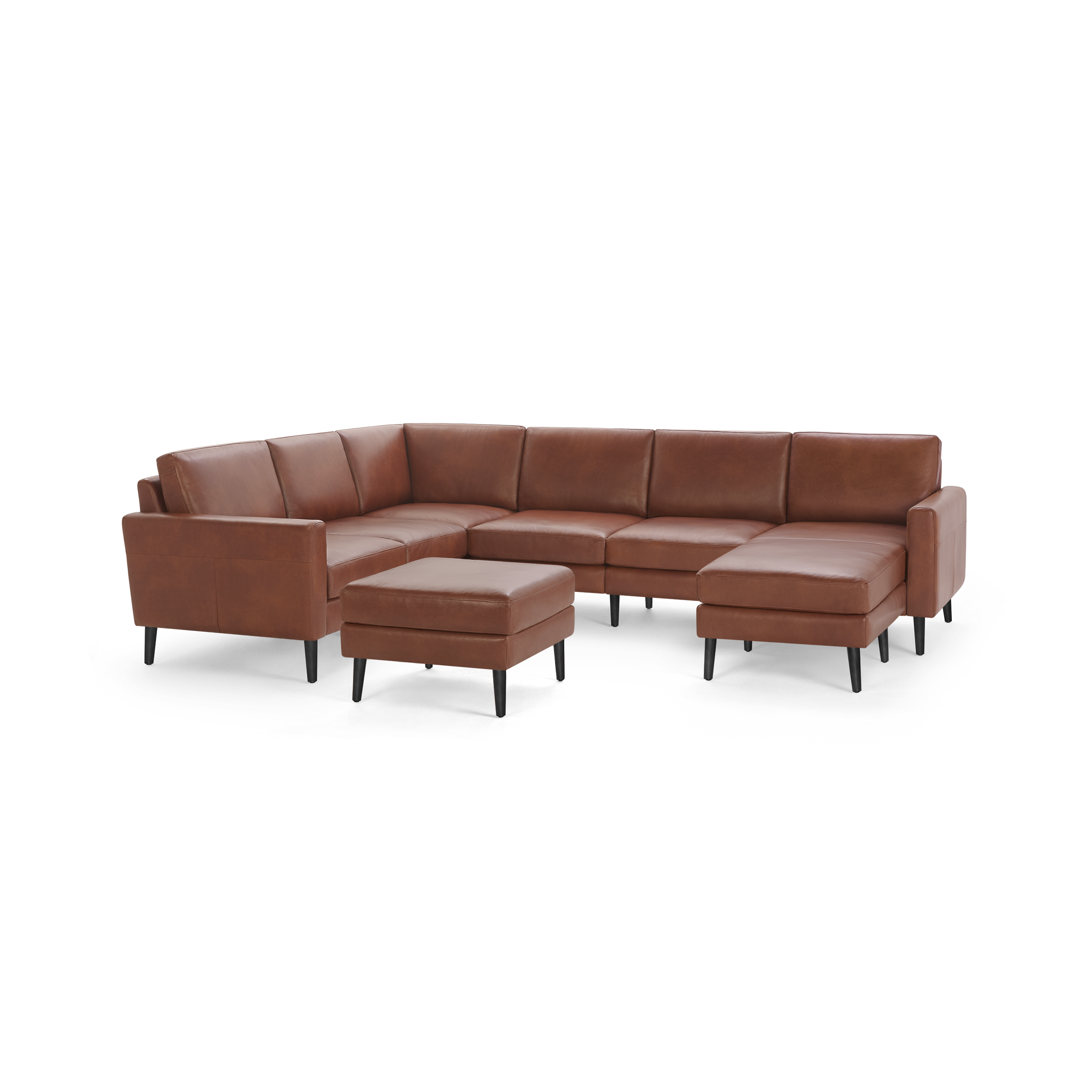 Modern sectional sofa with brown leather upholstery, black tapered legs, and a matching ottoman on a black background.