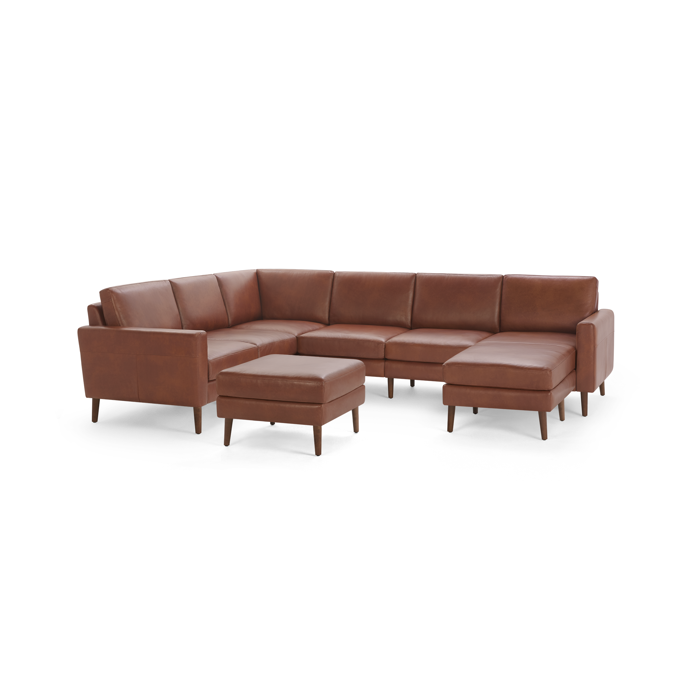 Brown leather U-shaped sectional sofa with clean lines and wooden legs, accompanied by a matching ottoman.