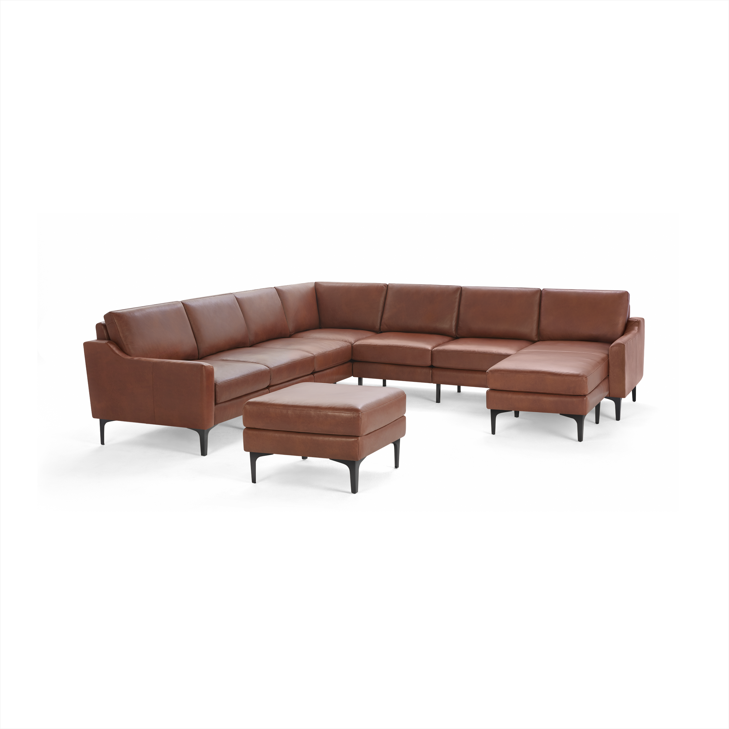 Brown leather L-shaped sectional sofa with matching ottoman, supported by slim black legs.