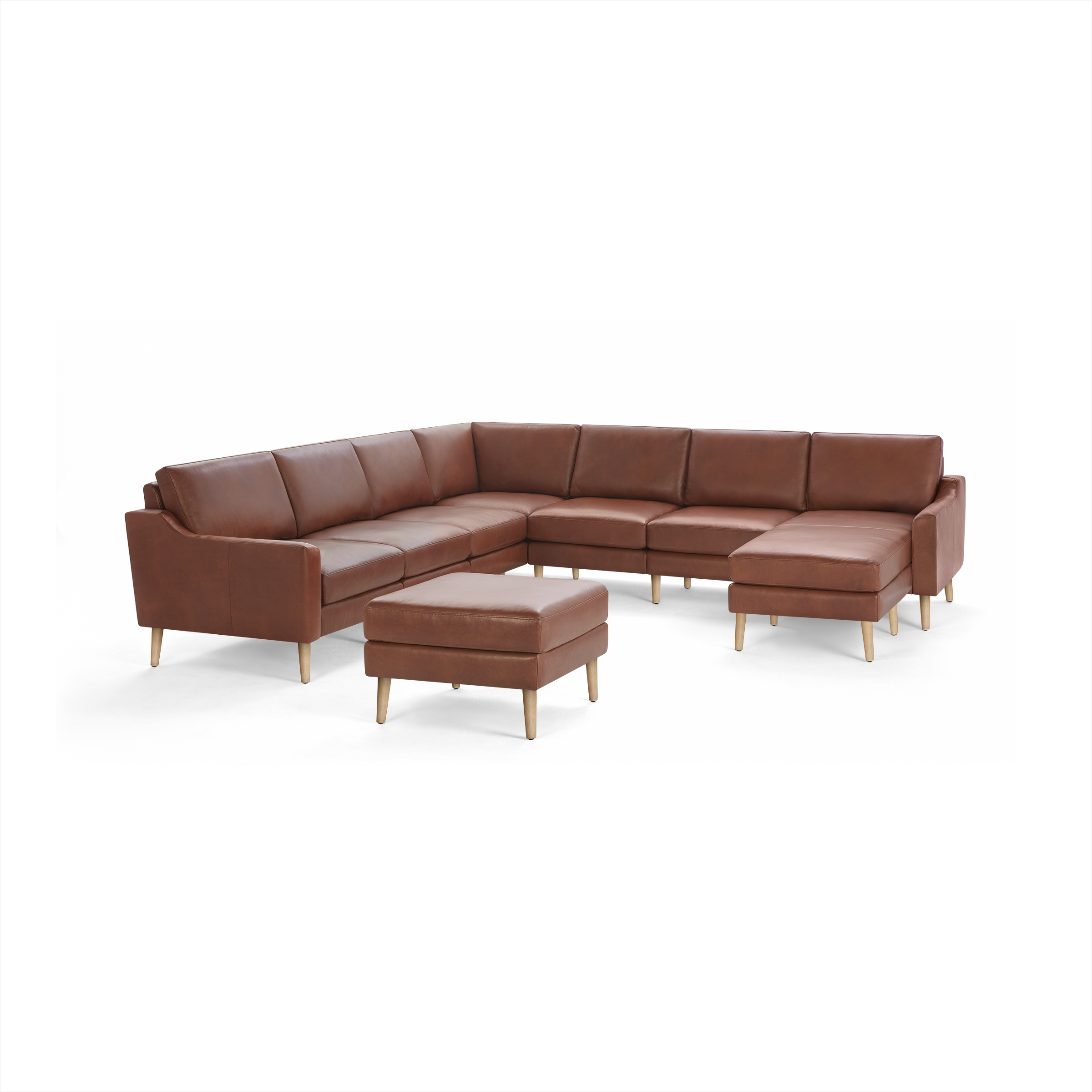 Brown leather L-shaped sectional sofa with matching ottoman, wooden legs, and clean modern design on black background.