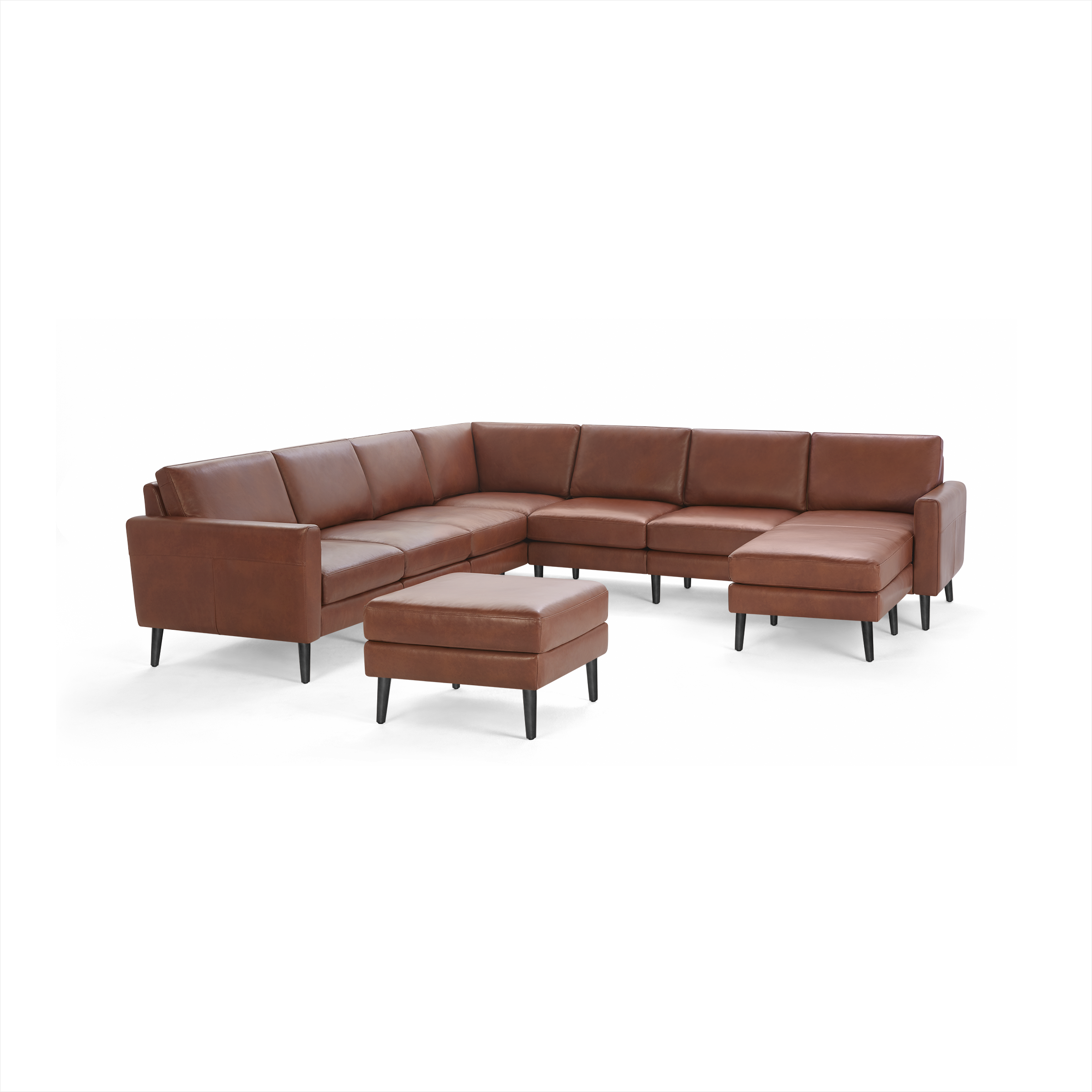 Brown leather sectional sofa with matching ottoman, featuring clean lines and black tapered legs on a black background.