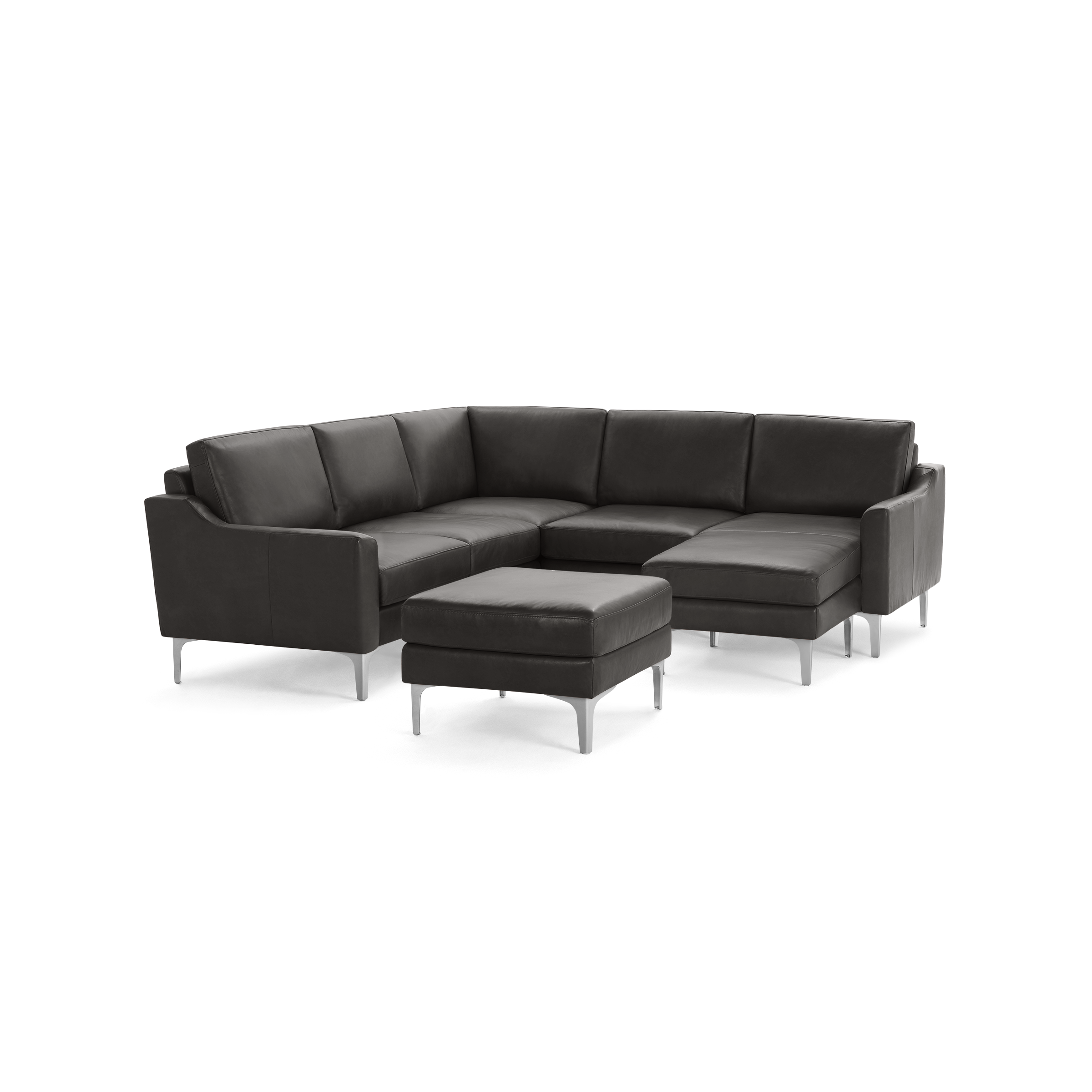 Modern dark gray leather sectional sofa with metal legs and a matching ottoman on a black background.